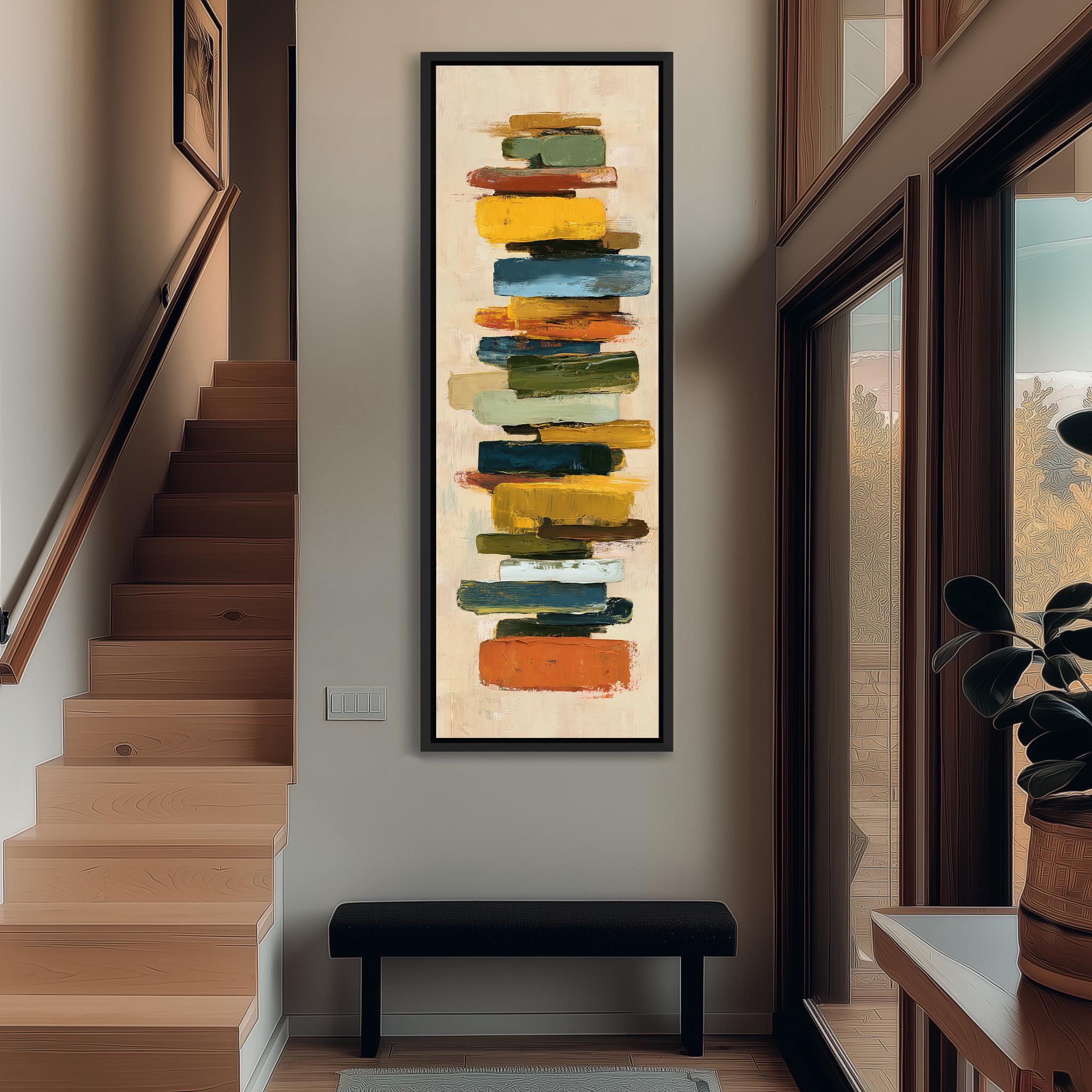 a modern art piece hanging on the wall of a hallway, with a wooden staircase and a bench in the foreground.