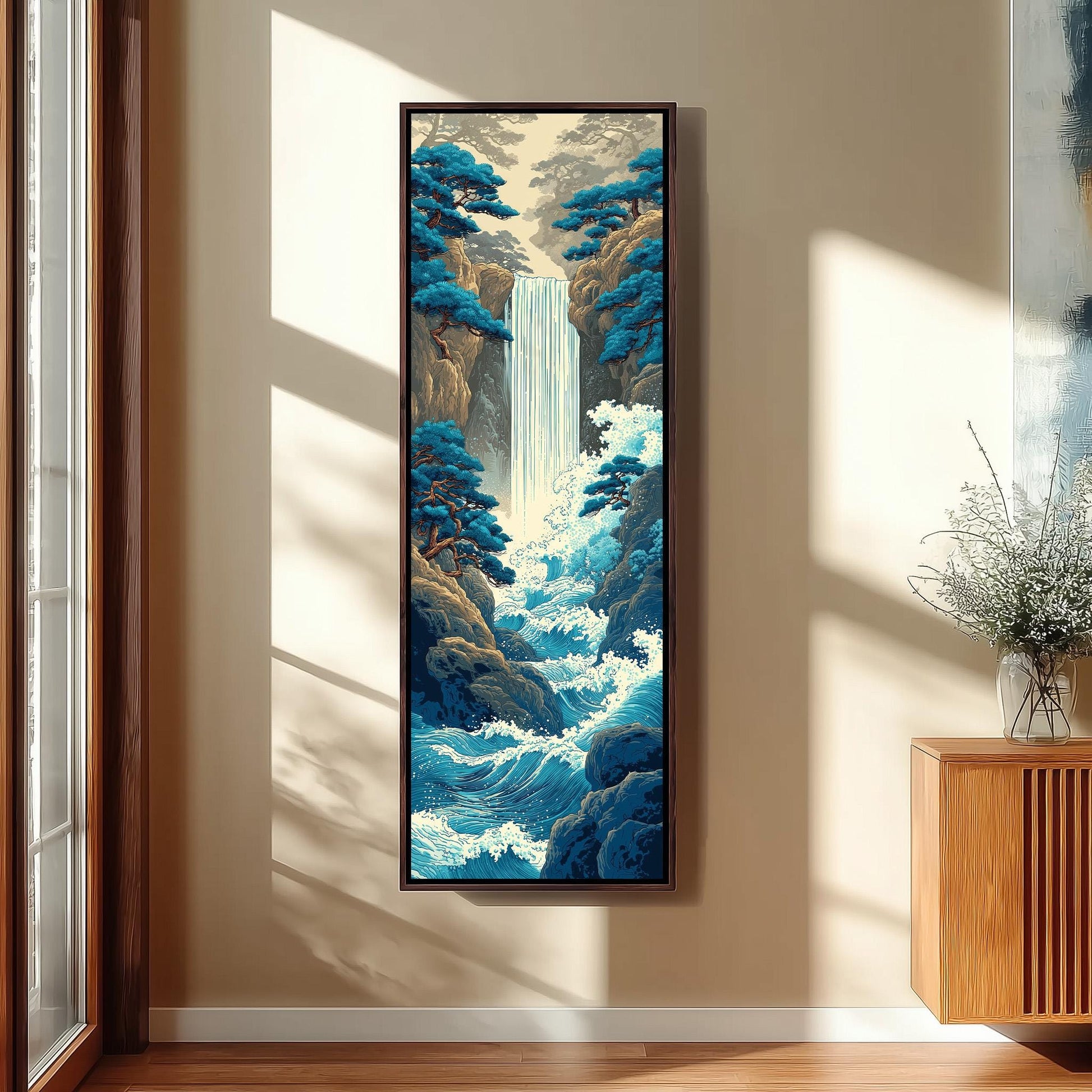 a large, framed painting of a waterfall surrounded by trees and rocks, hanging on a wall in a room with a wooden cabinet and a vase of flowers.