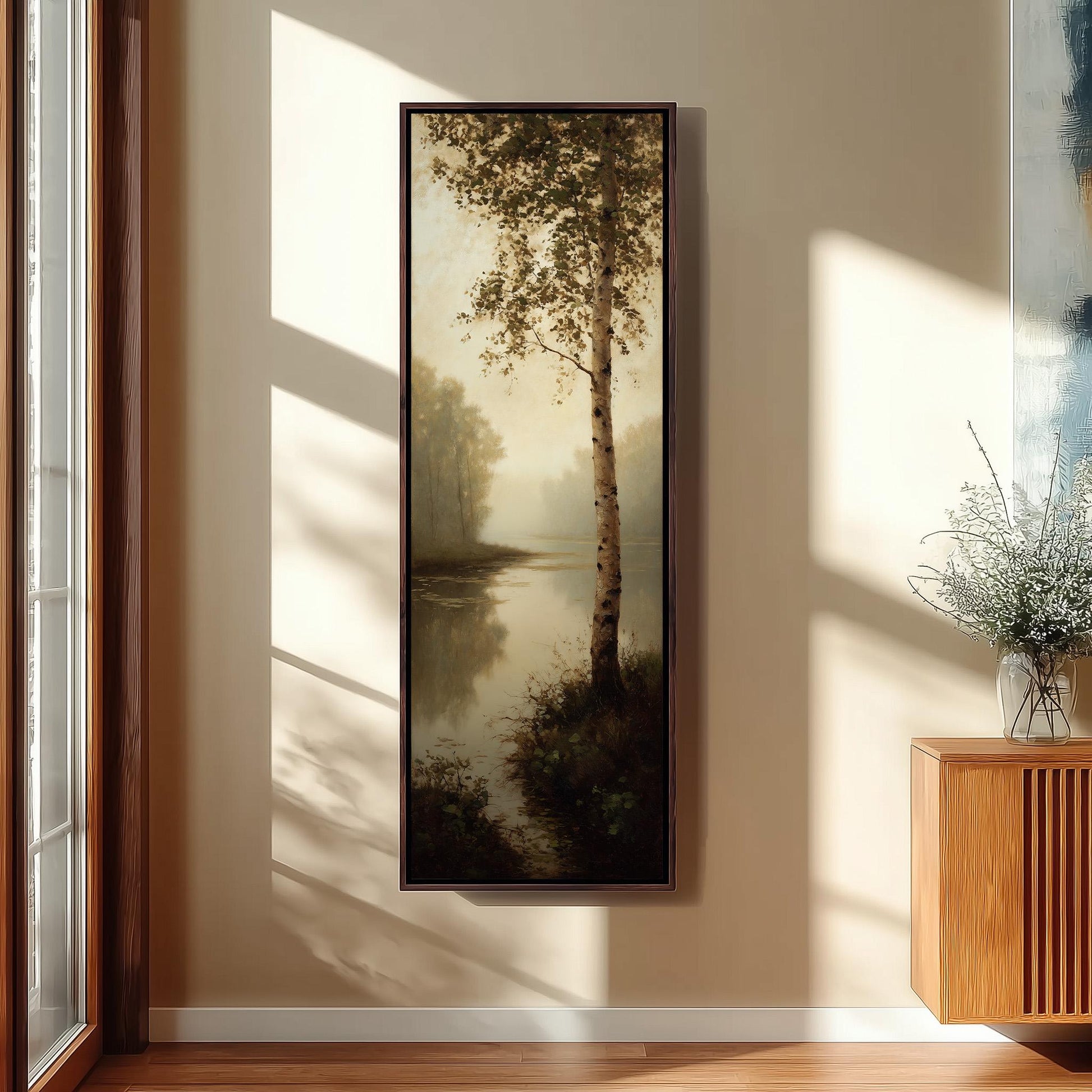 a large painting of a serene landscape with a tree and a body of water, hanging on a wall in a room with a wooden floor and a window.