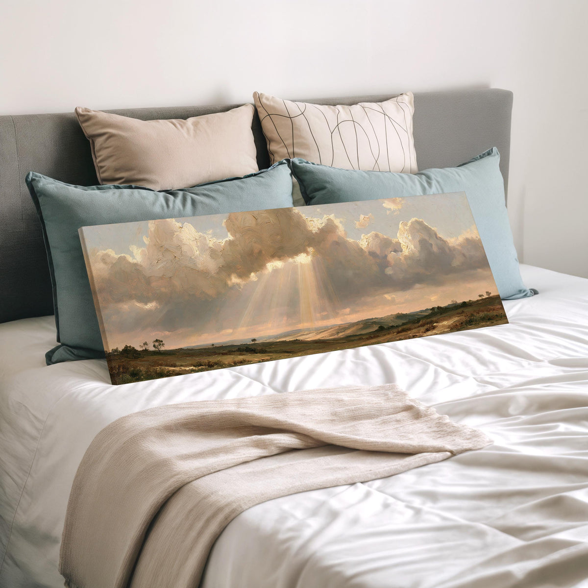 Sunbeams breaking through clouds over plains wide panoramic canvas print laid on a bed to show its size