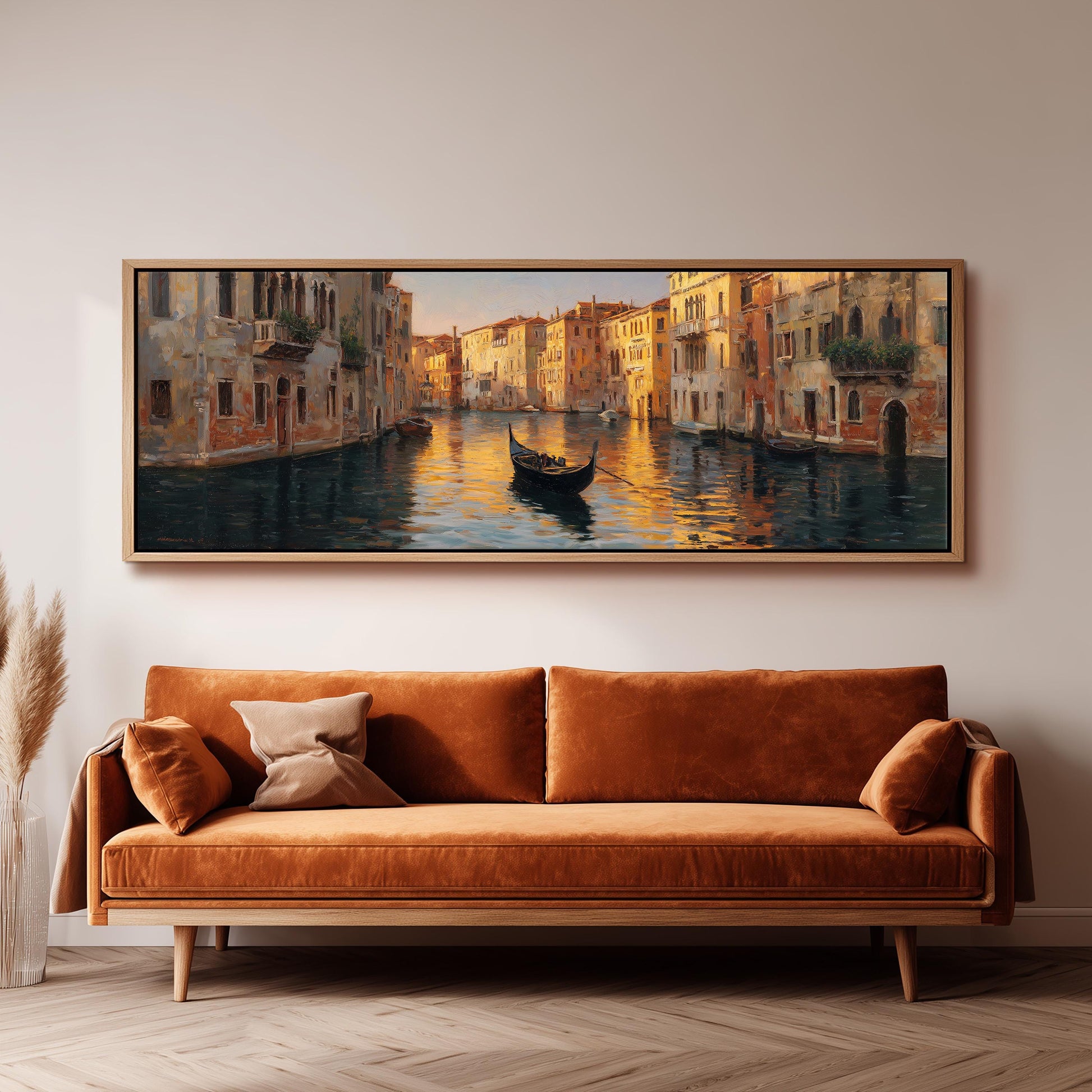 a large painting of a gondola on a canal, hanging on a wall above a brown sofa.