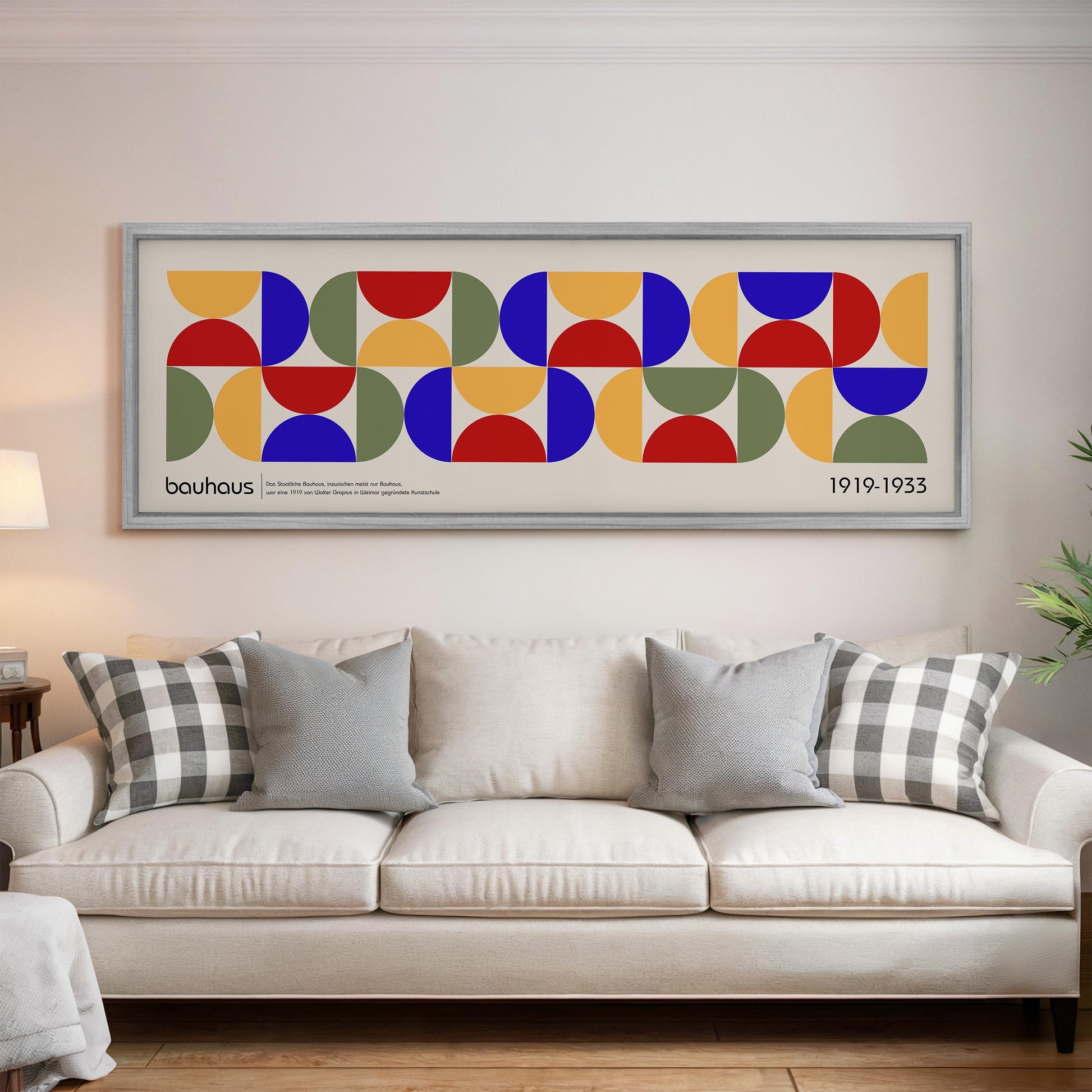 a large framed poster of a geometric pattern hanging on a wall above a white sofa with patterned throw pillows.