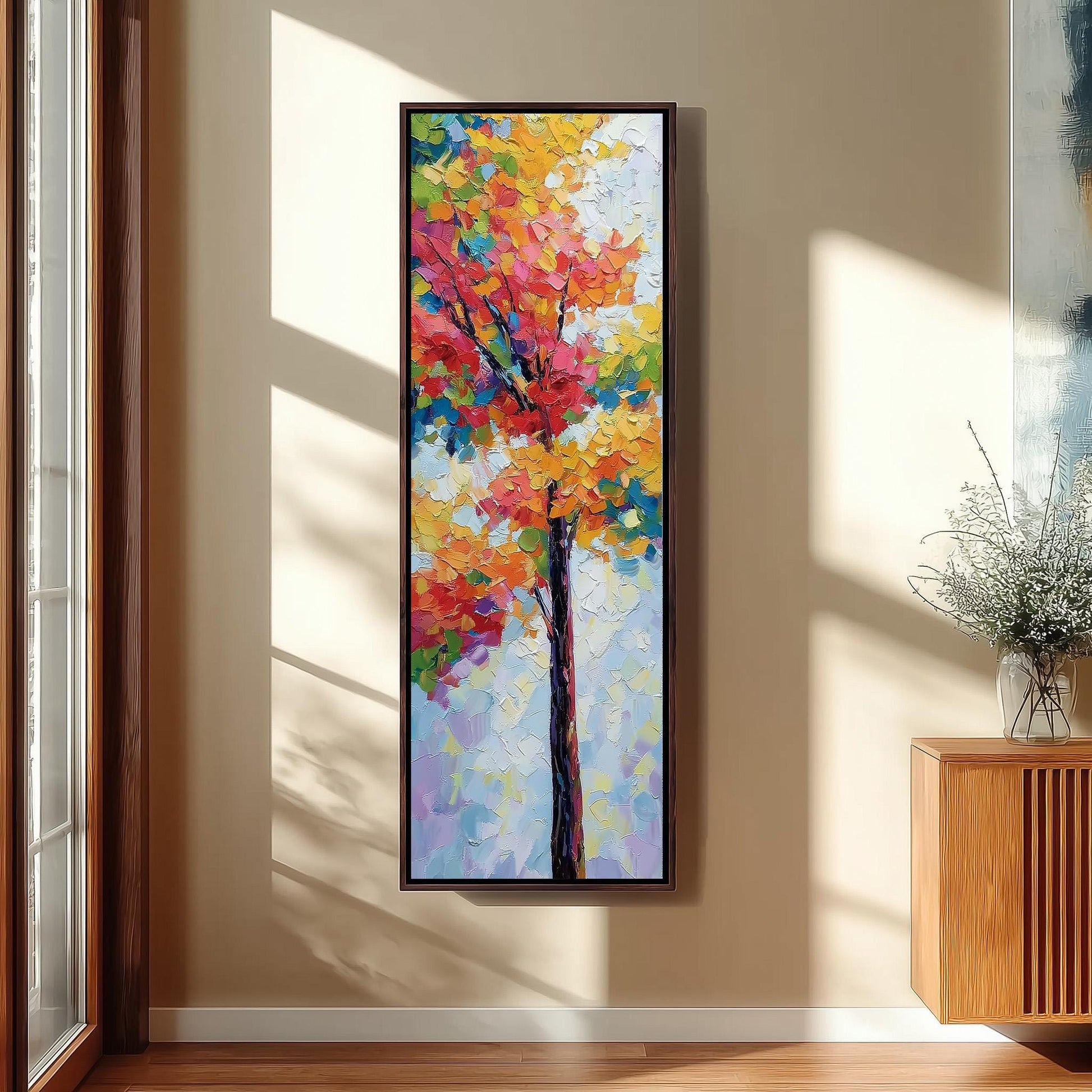 a large, colorful painting of a tree hanging on a wall in a room with a wooden floor and a window.