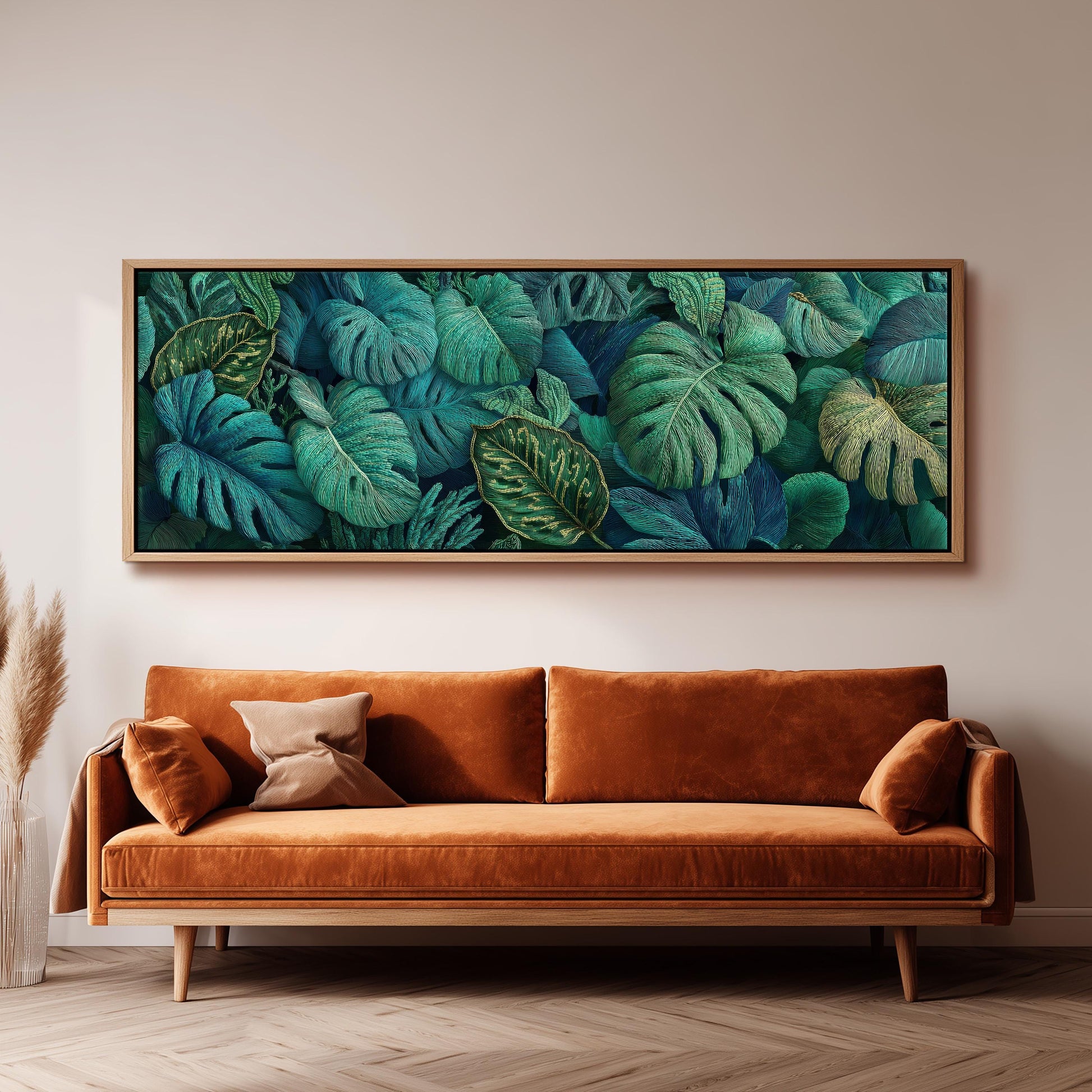 a large, framed painting of tropical leaves hanging on a wall above a brown sofa.