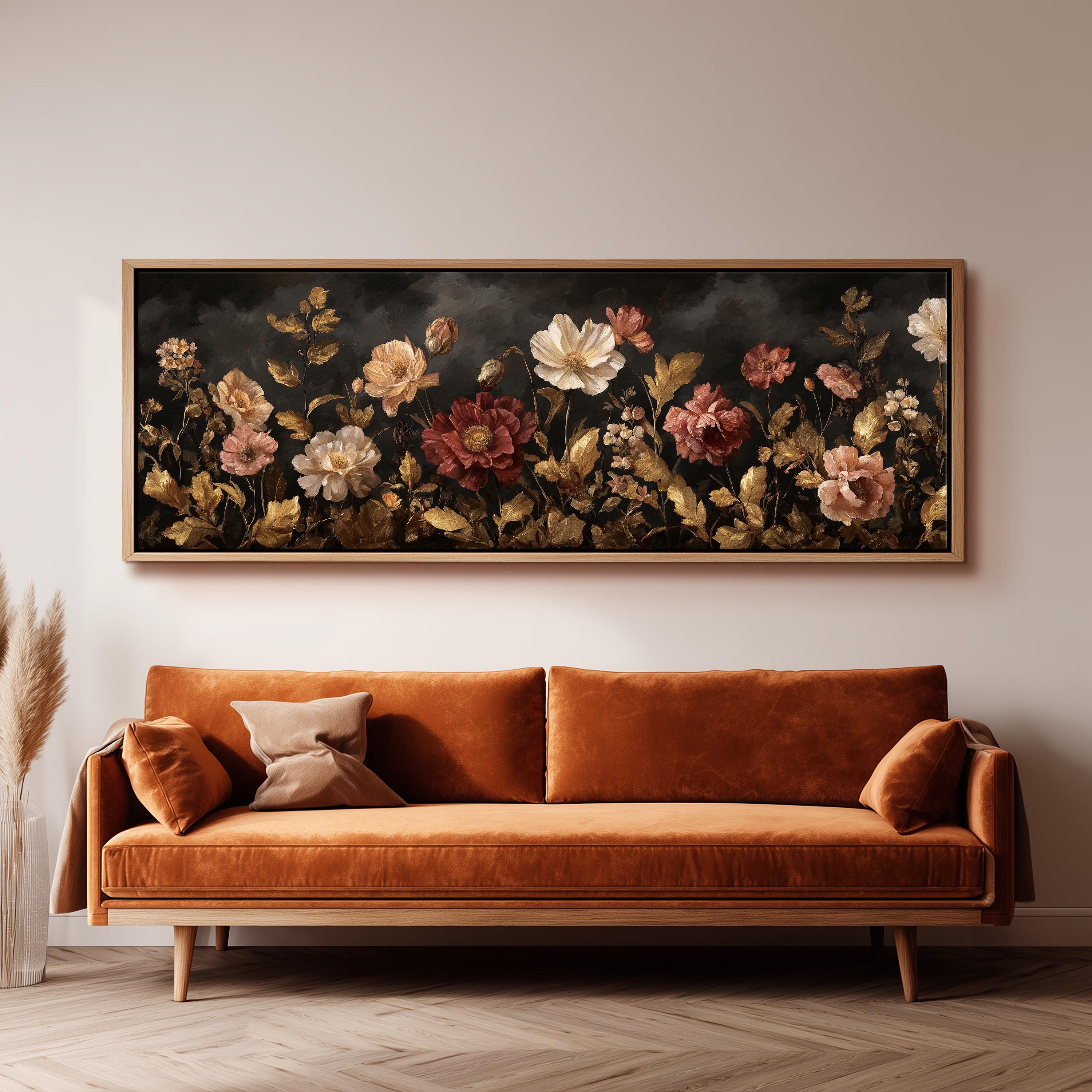 a large, ornate painting of flowers hanging on a wall above a brown sofa.