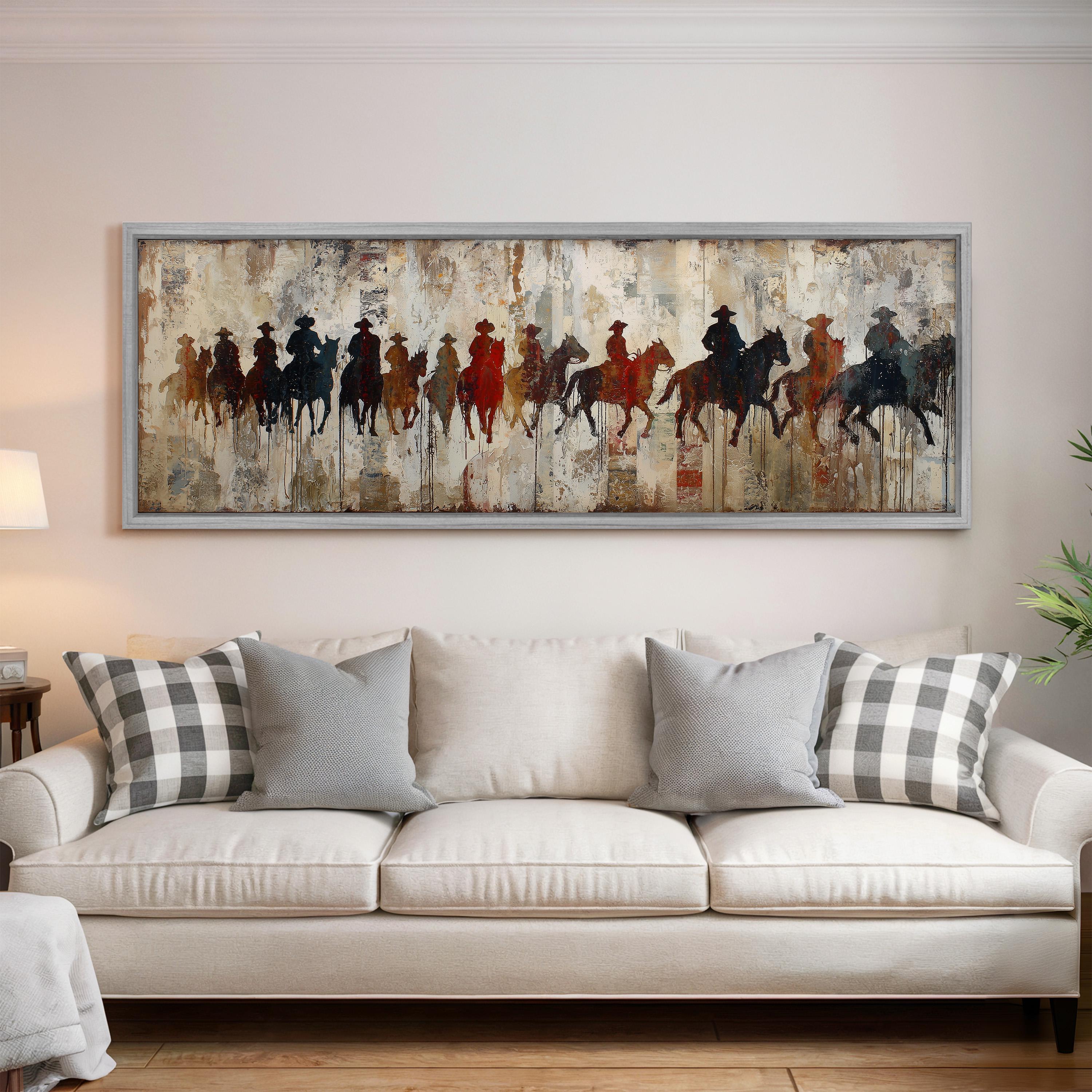 a large painting of people riding horses on a wall above a white couch with gray and white plaid throw pillows.