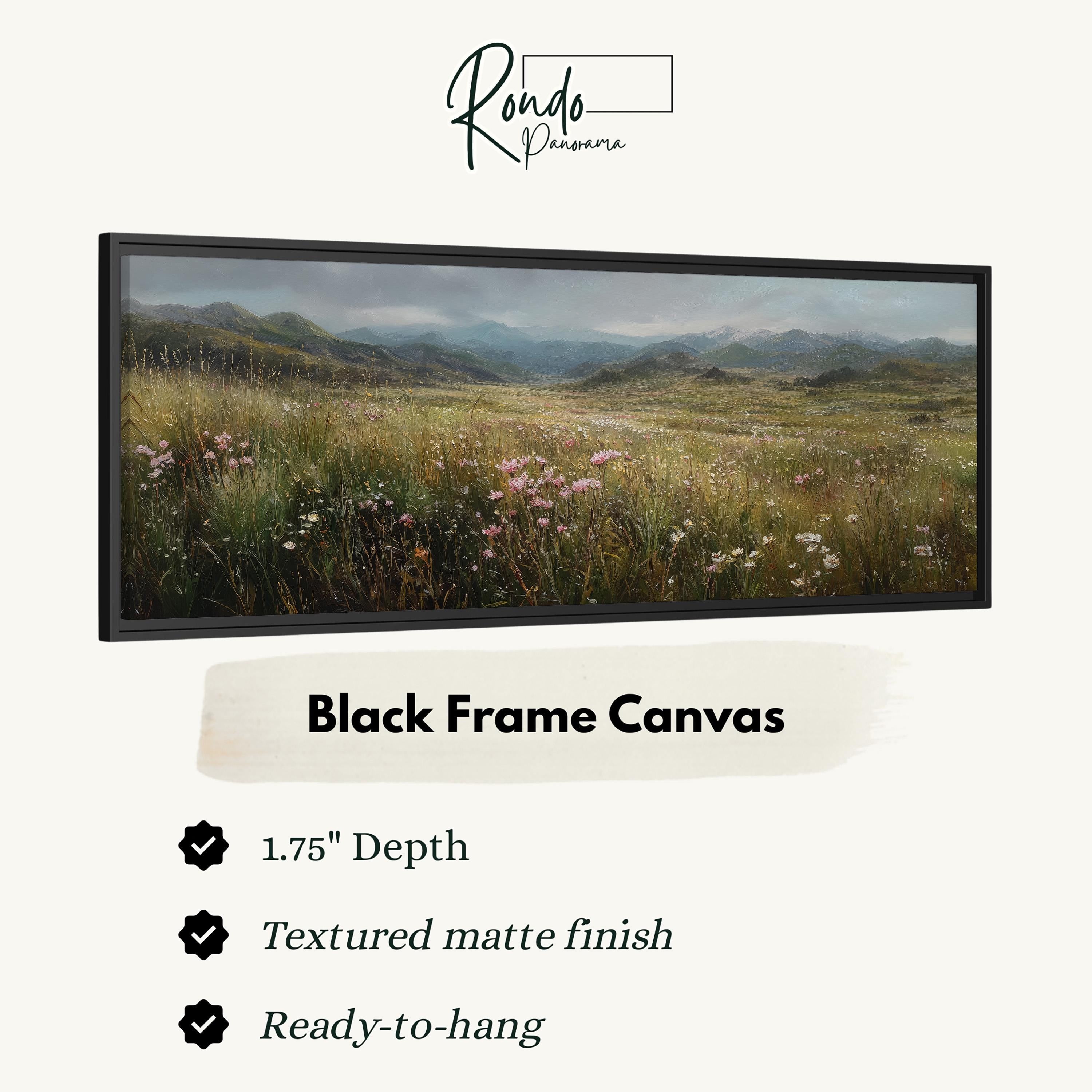 The image is a black frame canvas depicting a serene landscape with a field of flowers and mountains in the background.