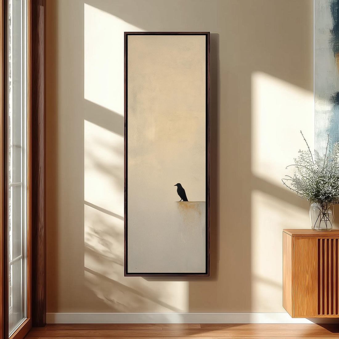 a black bird perched on a ledge, with a wooden cabinet and a vase of flowers to the right of the frame.