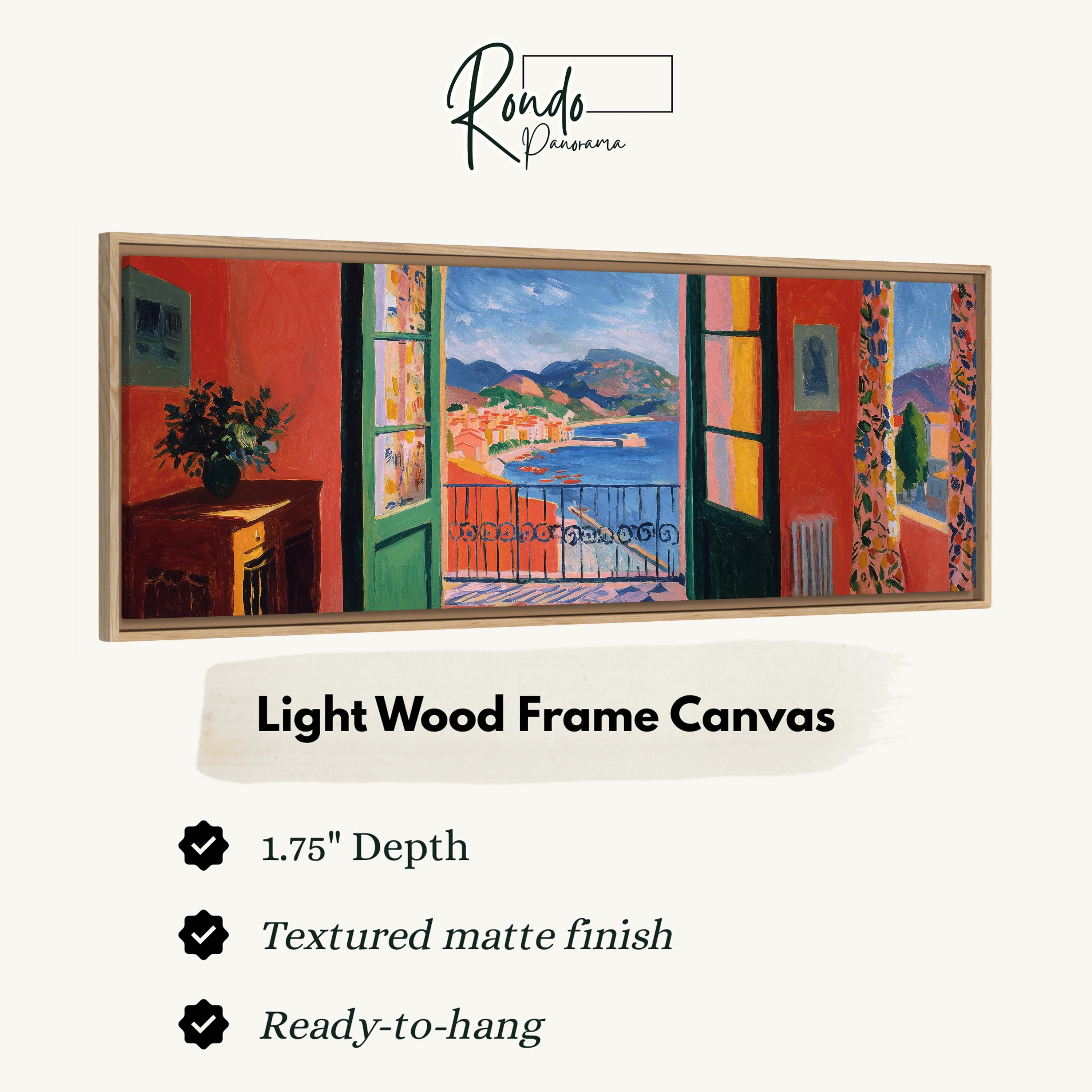 The image is a light wood frame canvas depicting a coastal town with colorful buildings and a view of the ocean through open windows.