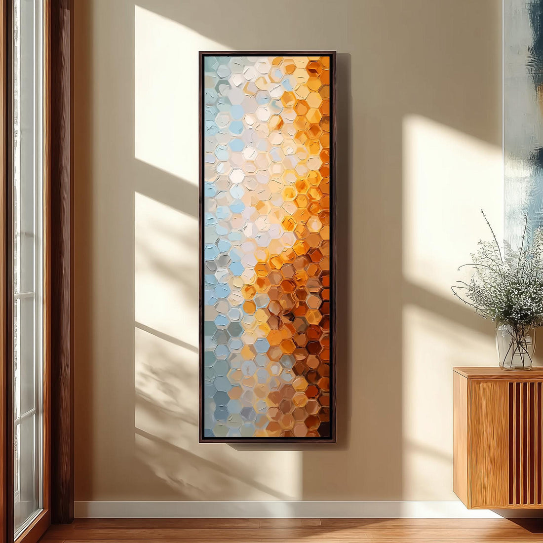 a large, colorful abstract painting hanging on a wall in a room with a wooden cabinet and a vase of flowers.