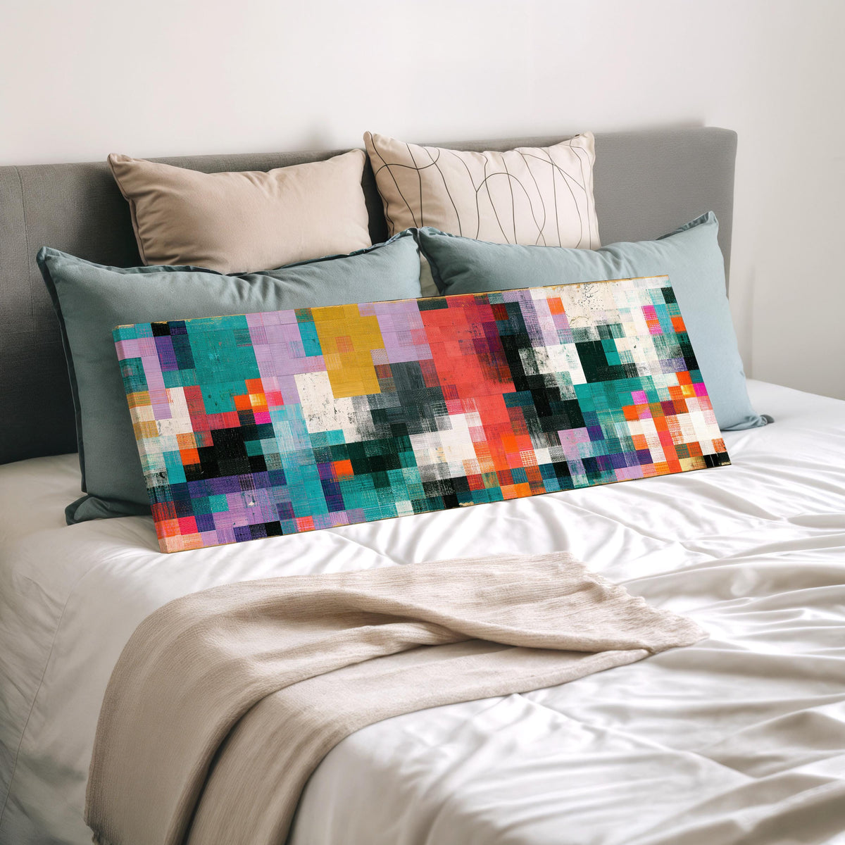 Teal and coral patchwork color blocks wide panoramic canvas print laid on a bed to show its size