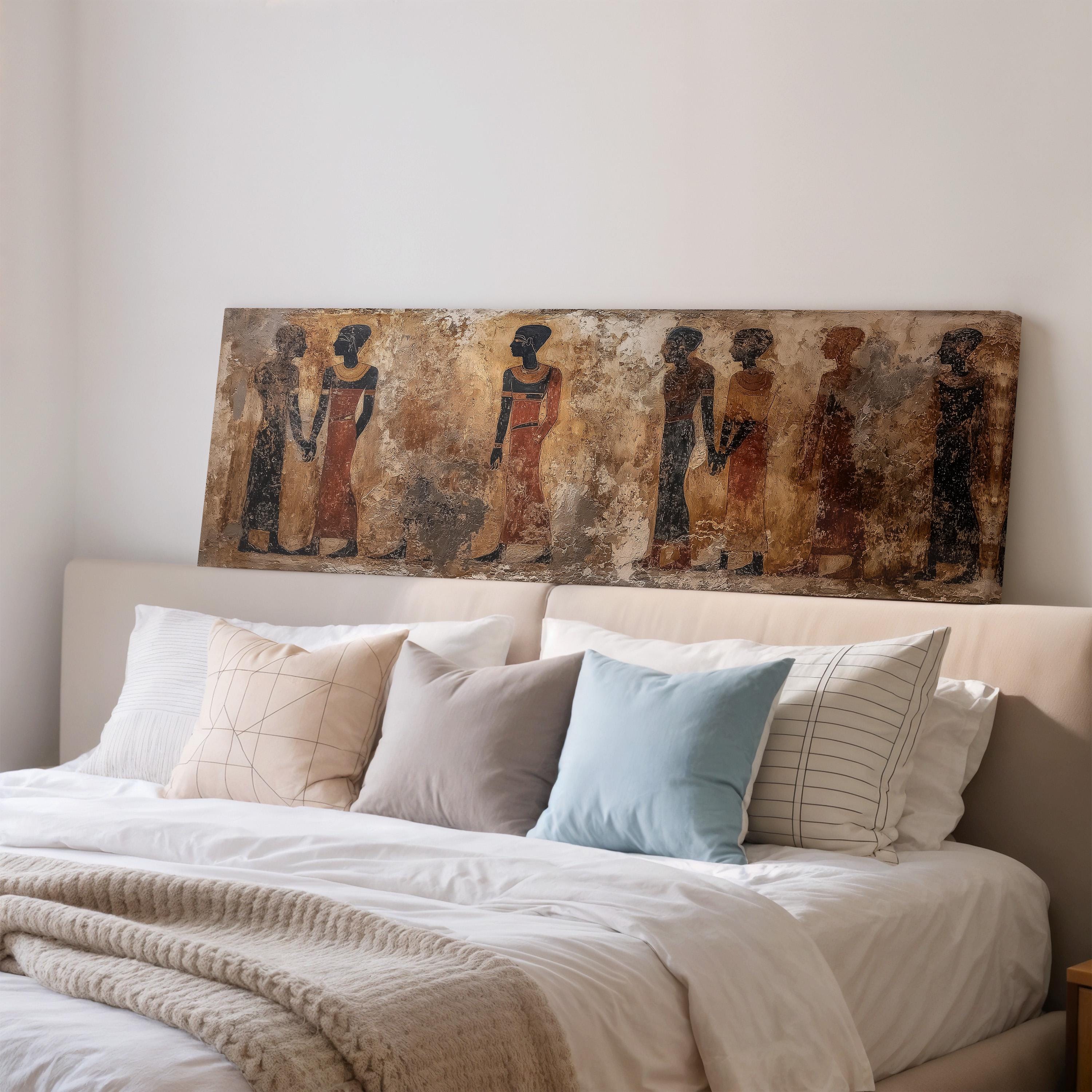 a large painting of ancient Egyptian figures displayed on a wall above a bed with white bedding and pillows.