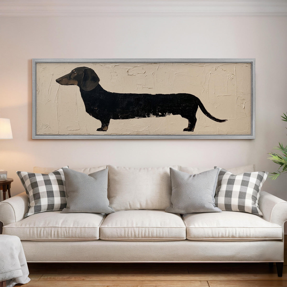 Black dachshund silhouette panoramic canvas print above a white sofa in a bright living room
