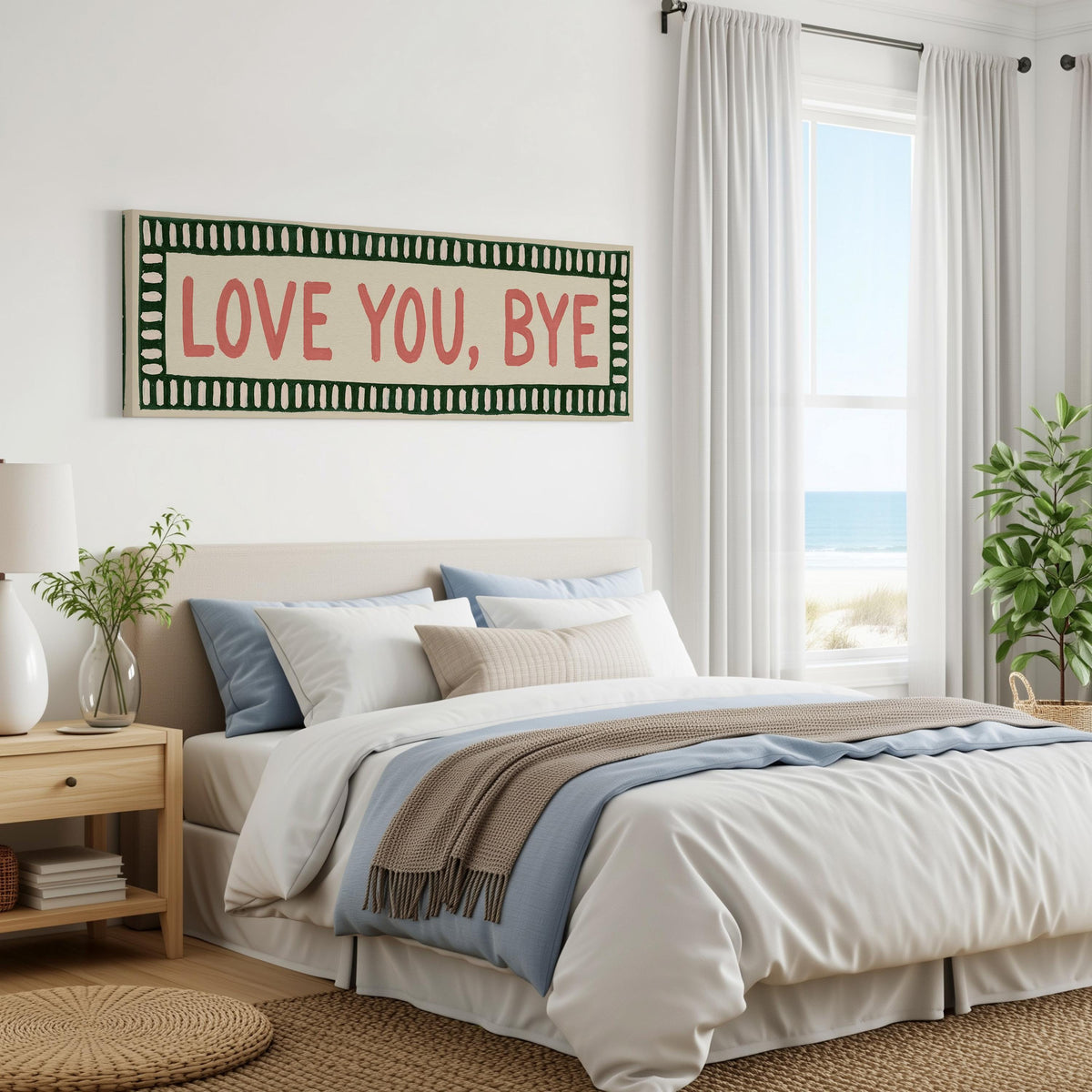 Love you, bye sign with a green border panoramic canvas print above a bed in a coastal bedroom