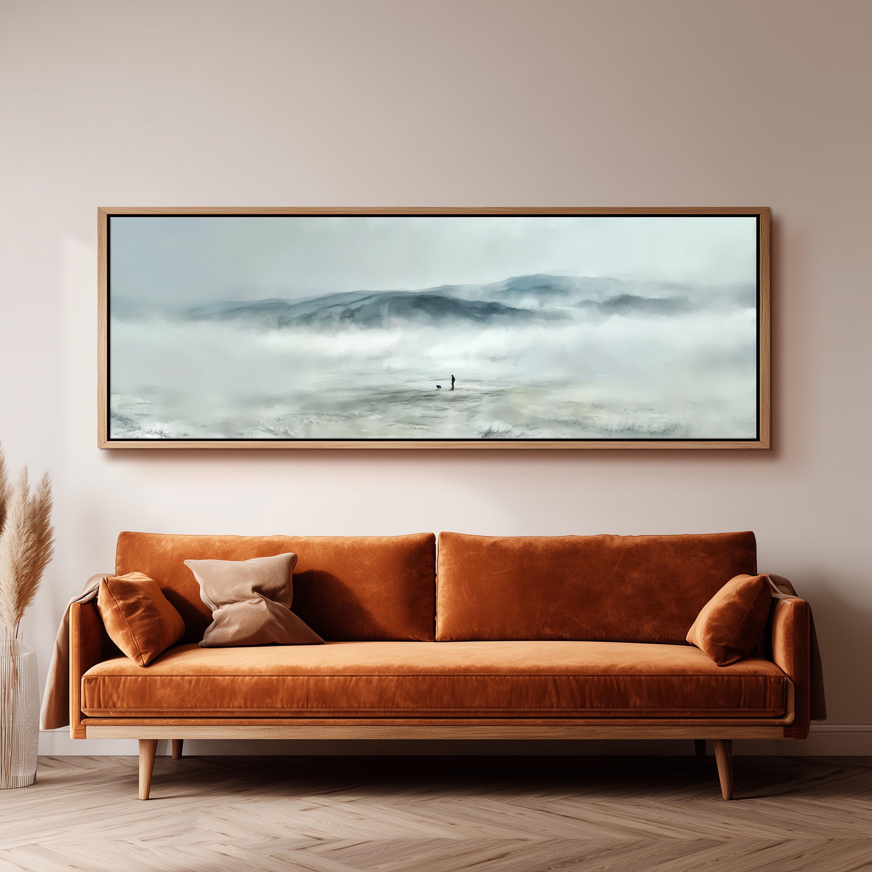 a large, framed painting of a misty mountain landscape hanging on a wall above a brown sofa with orange cushions.