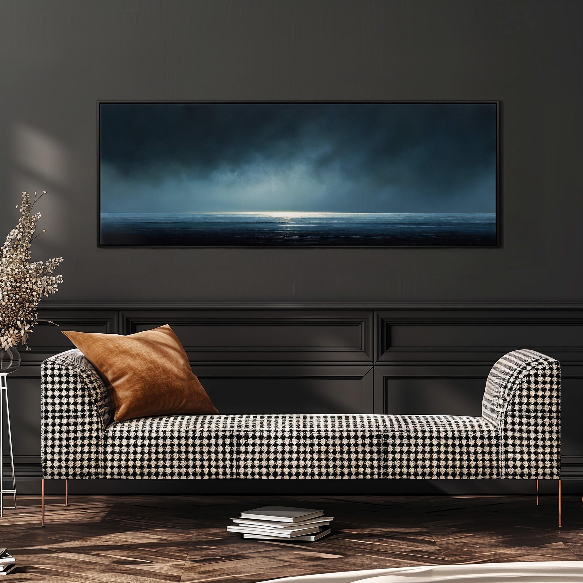 a modern living room with a black and white checkered sofa, a stack of books, and a large painting of a stormy ocean scene hanging on the wall.