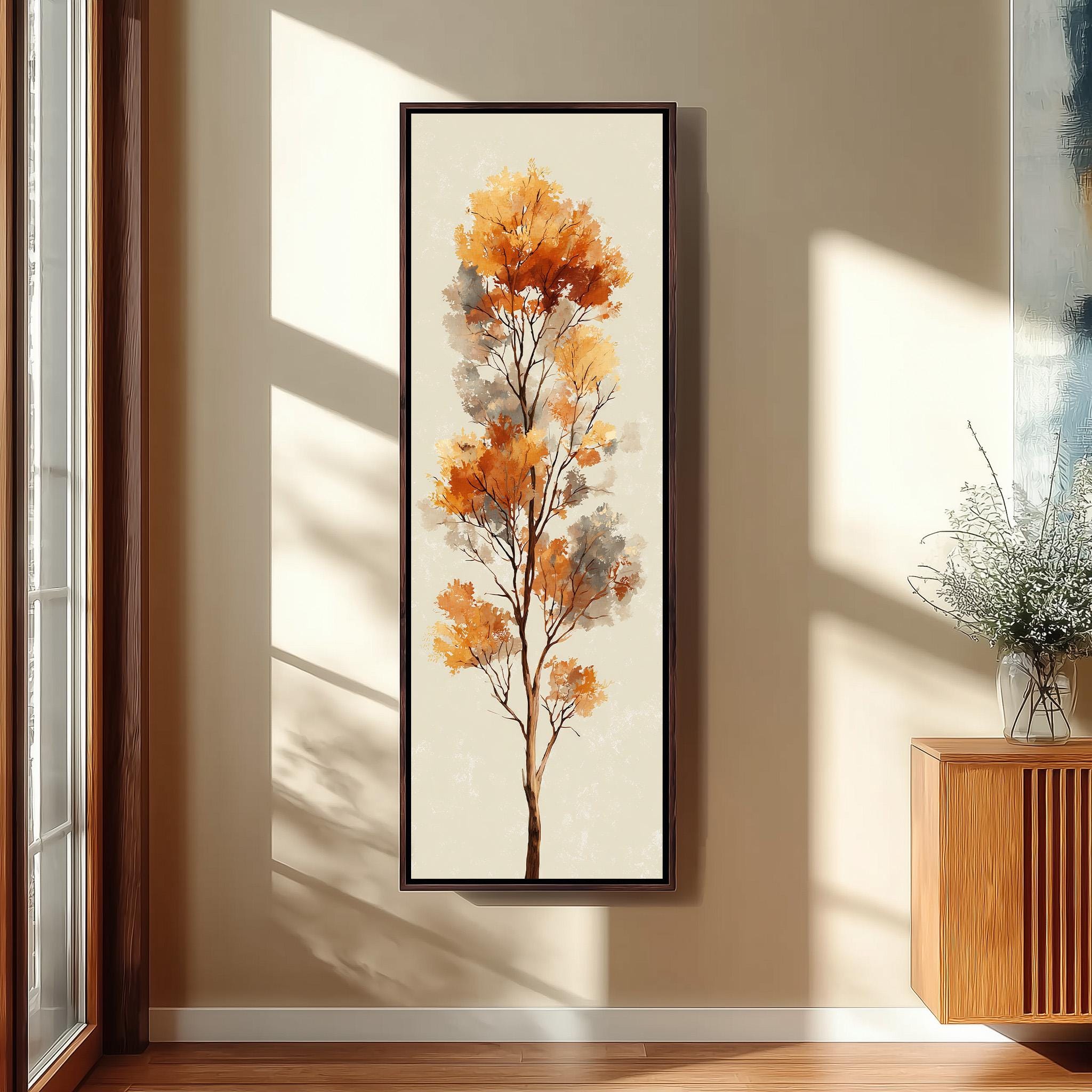 a large framed painting of a tree with orange leaves hanging on a wall in a room with a wooden floor and a window.