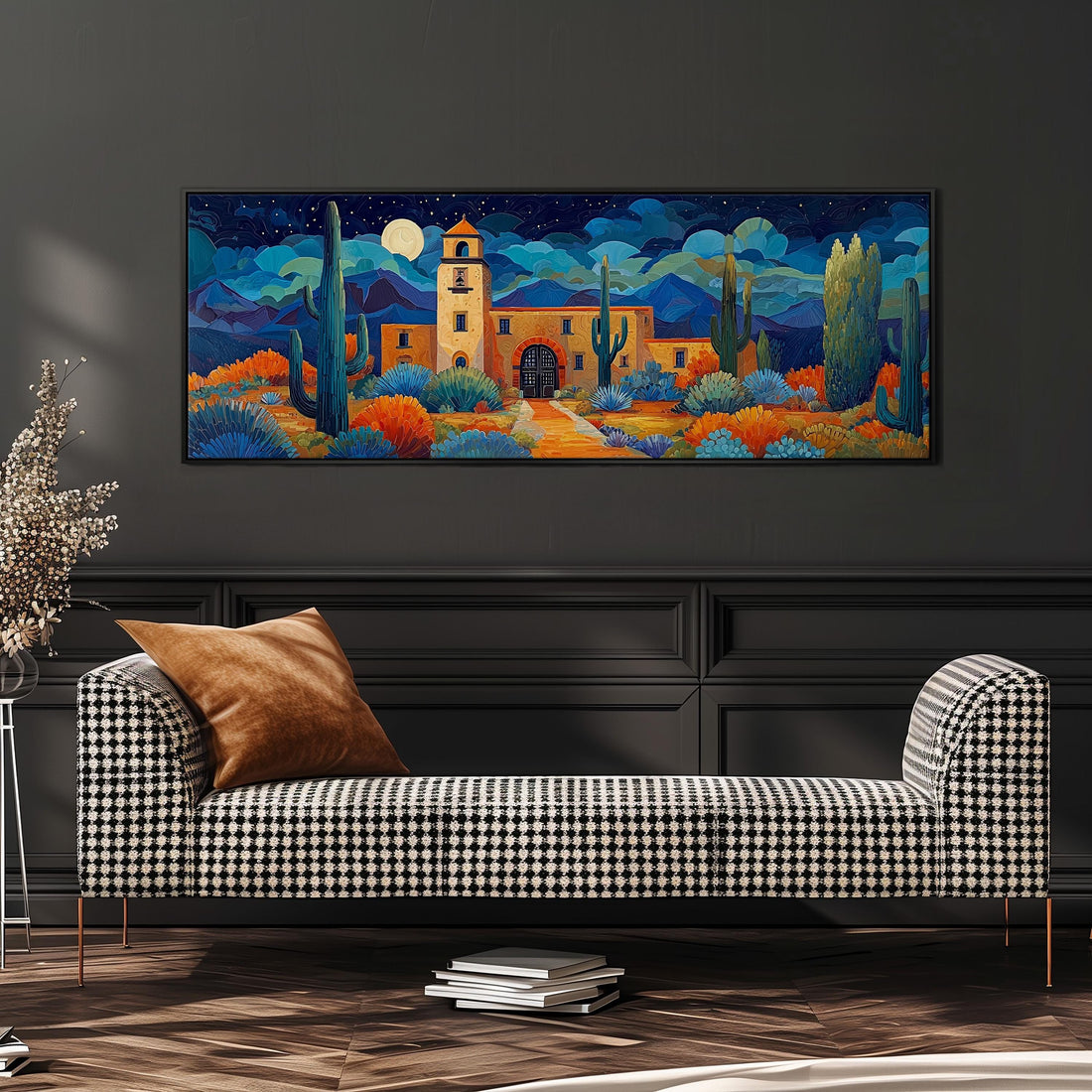 a large, colorful painting of a desert landscape with a building, cacti, and a moon in the night sky. The painting is hung on a wall above a brown sofa with a wooden frame.