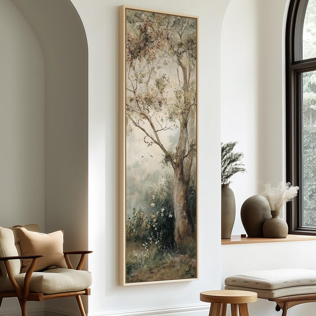 a large painting of a tree hanging on a wall, with a cozy seating area and decorative elements such as vases and a potted plant in the background.