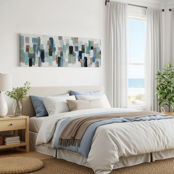 a serene and modern bedroom with a large bed, a nightstand, and a painting on the wall. The room has a beach view, and the overall color scheme is predominantly white and blue.