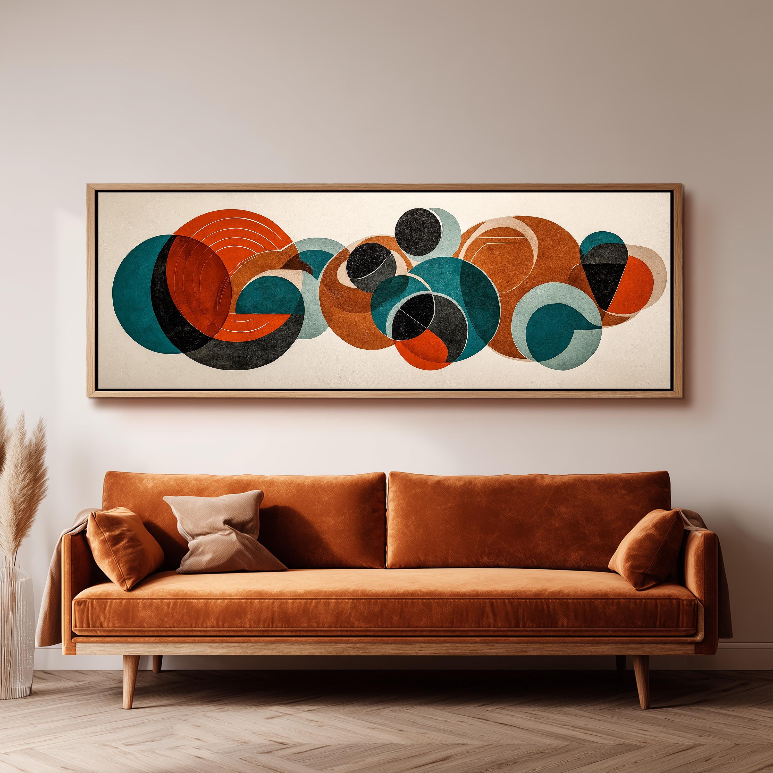 a large abstract painting hanging on a wall above a brown sofa with a wooden frame.