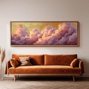 a large, framed painting of clouds hanging on a wall above a brown sofa.