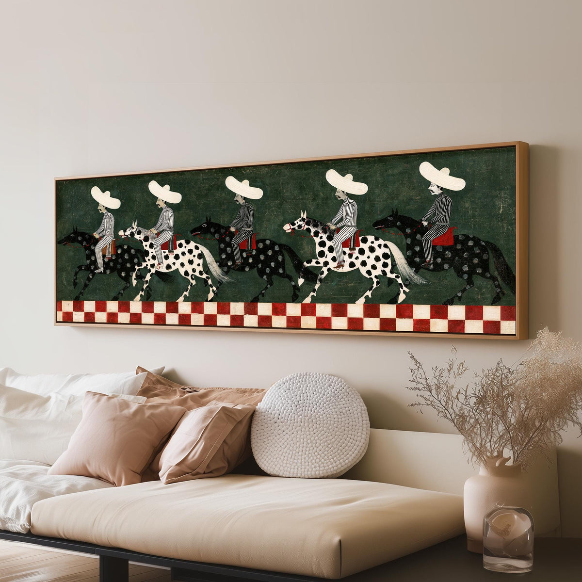 Riders in sombreros on spotted horses panoramic canvas print above a sofa in a living room