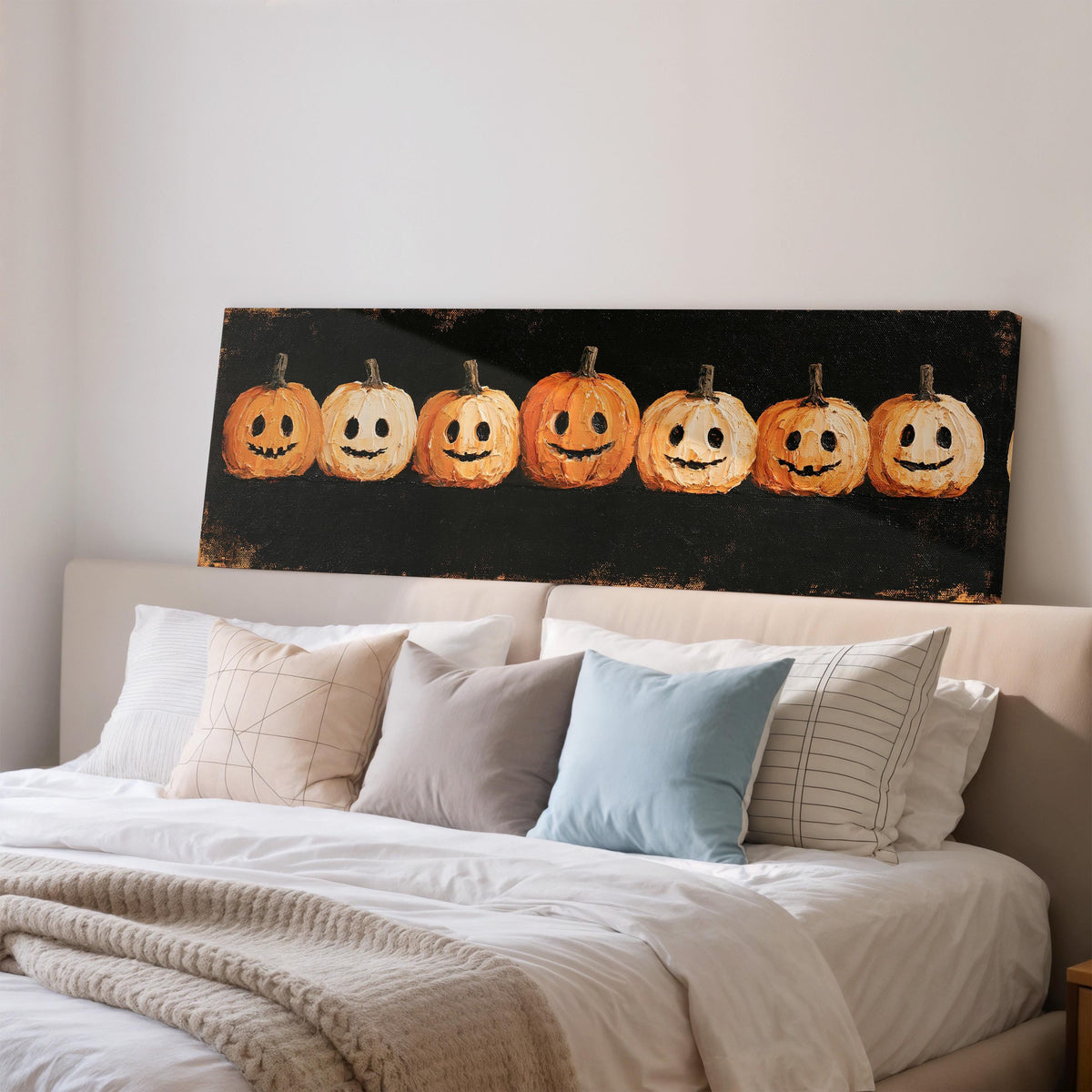 Row of smiling jack-o'-lanterns wide panoramic canvas print above a bed in a bedroom