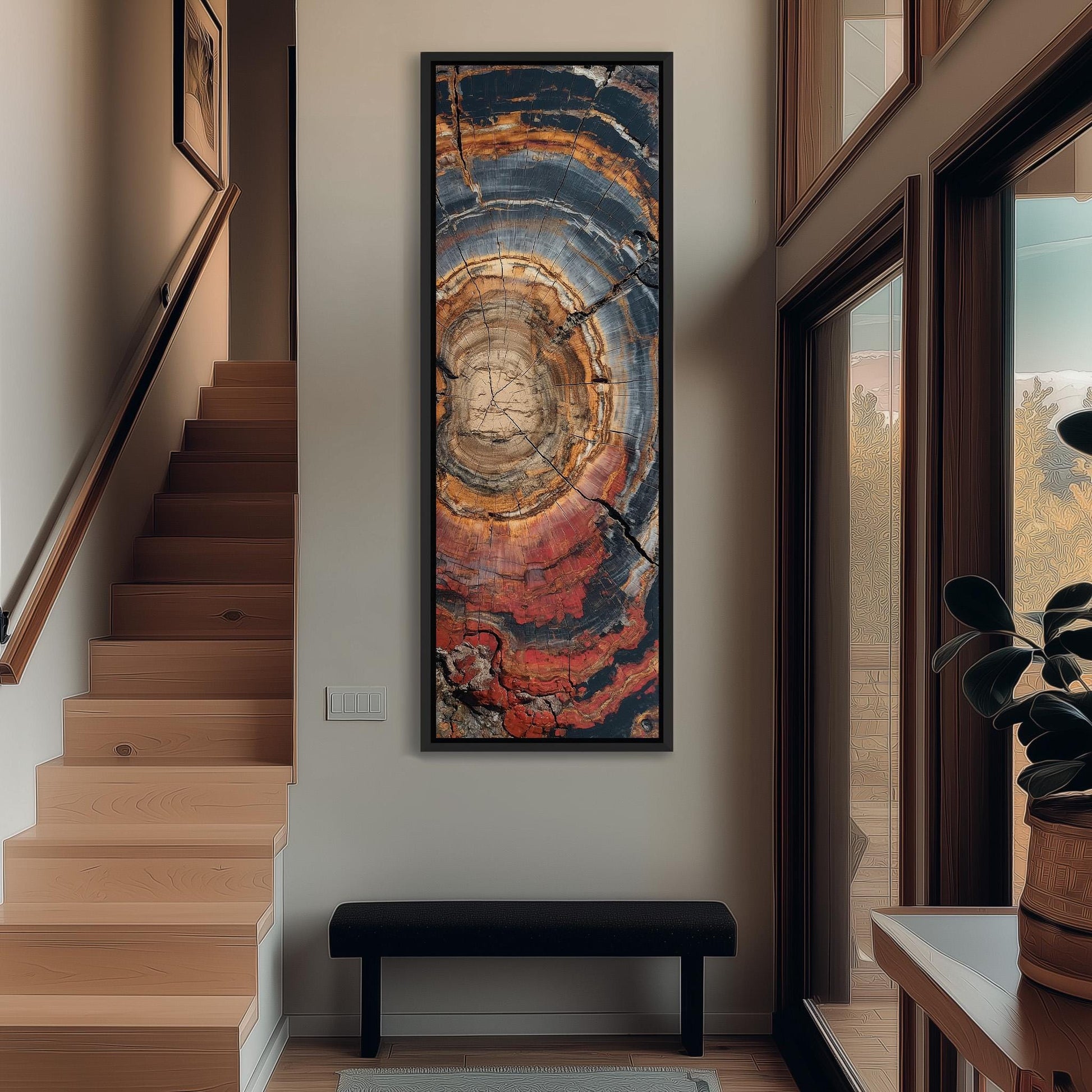a hallway with a large abstract painting hanging on the wall, a wooden staircase, a black bench, and a potted plant.