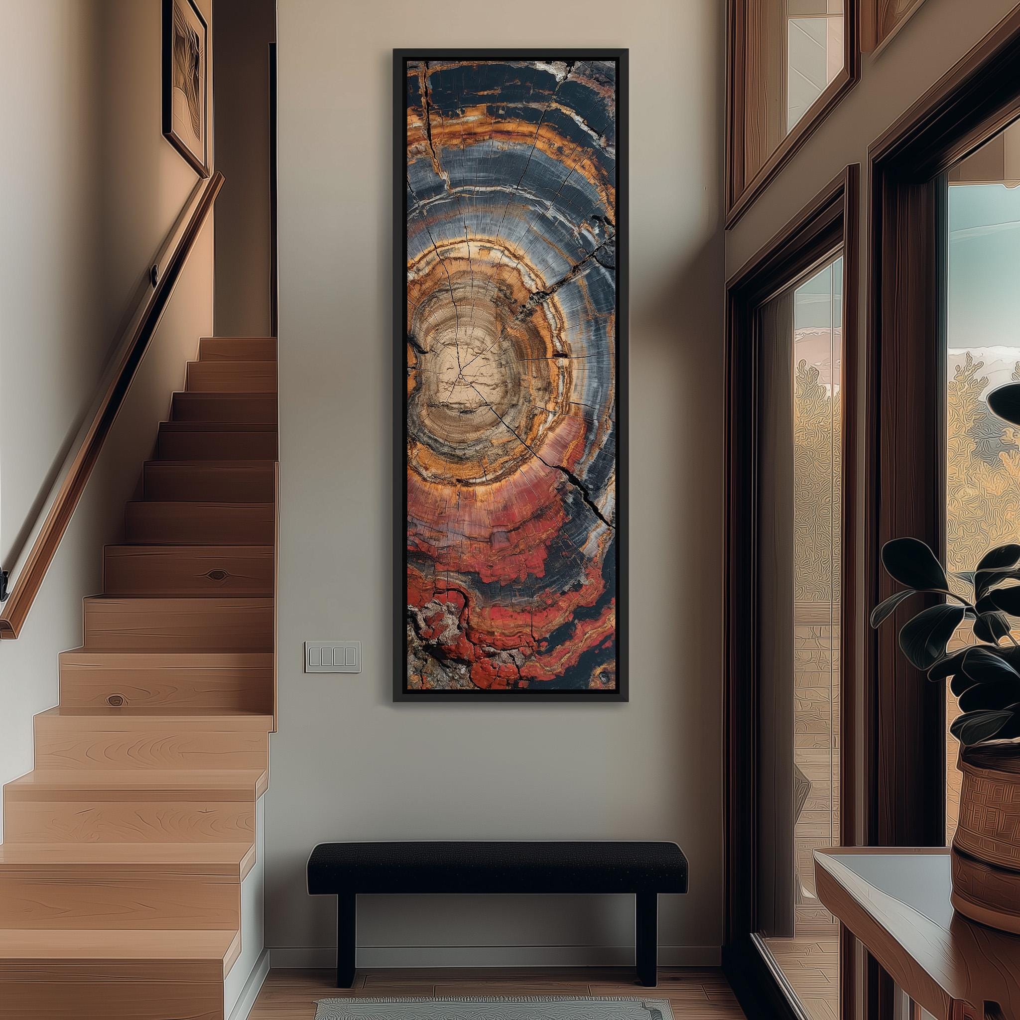 a hallway with a large abstract painting hanging on the wall, a wooden staircase, a black bench, and a potted plant.