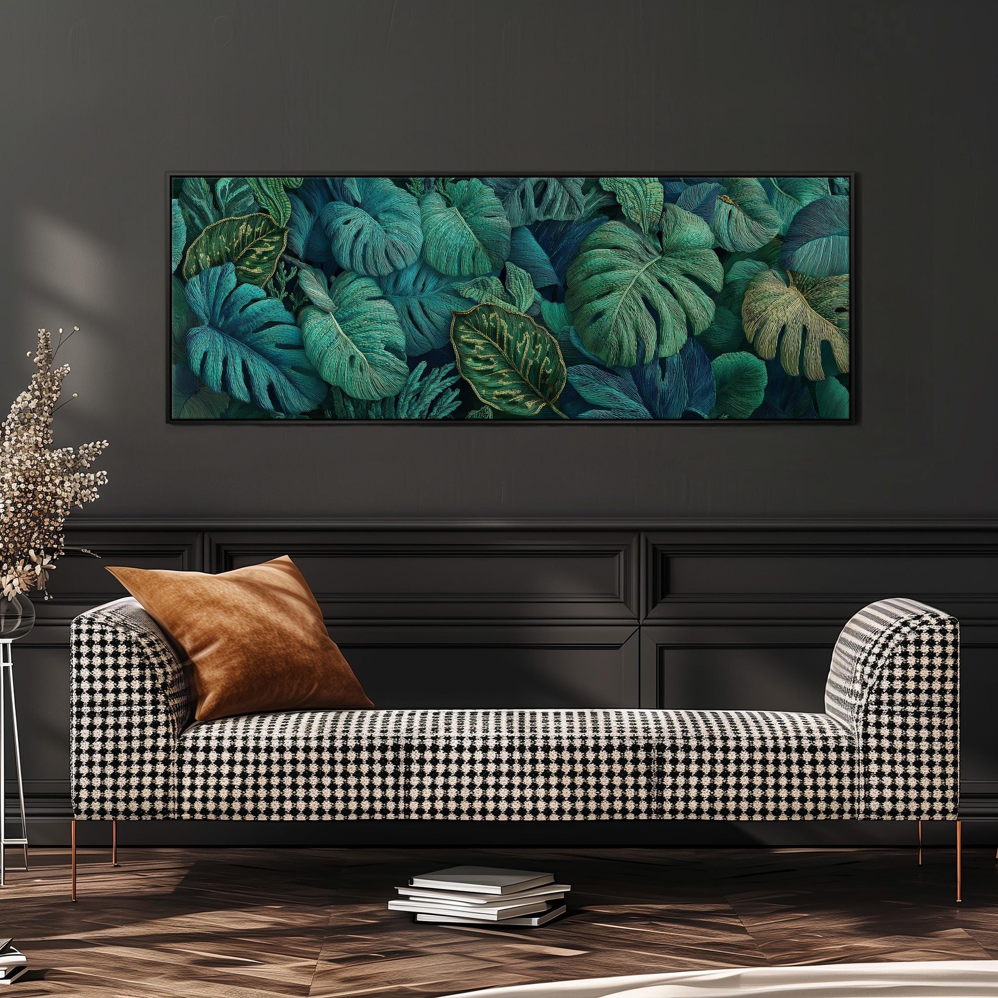 a large, framed painting of tropical leaves hanging on a wall above a black and white checkered sofa in a living room setting.