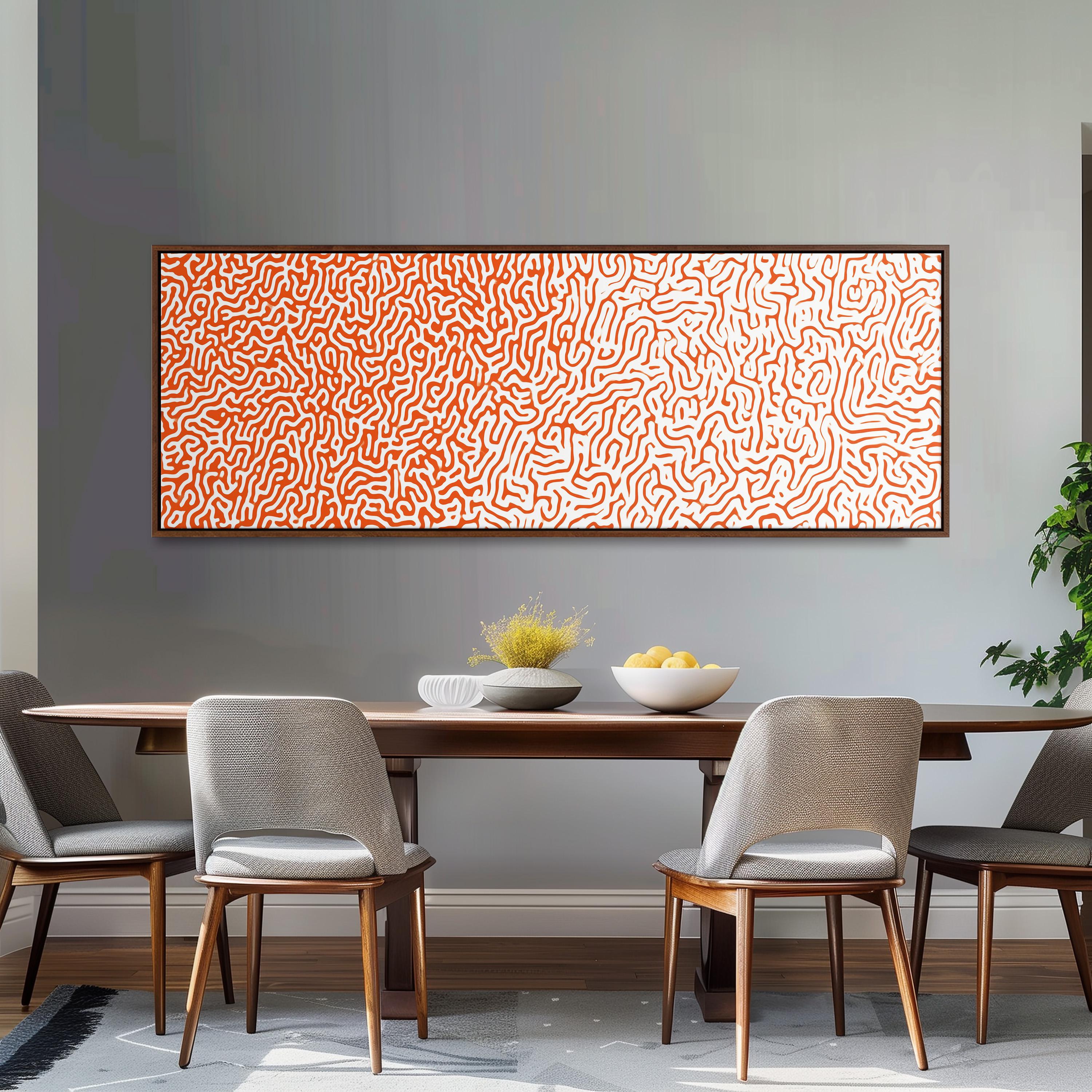 a dining room with a wooden table and four chairs. Above the table, there is a large abstract painting with a pattern of orange and white lines. The table is set with a bowl of fruit and a vase of flowers.
