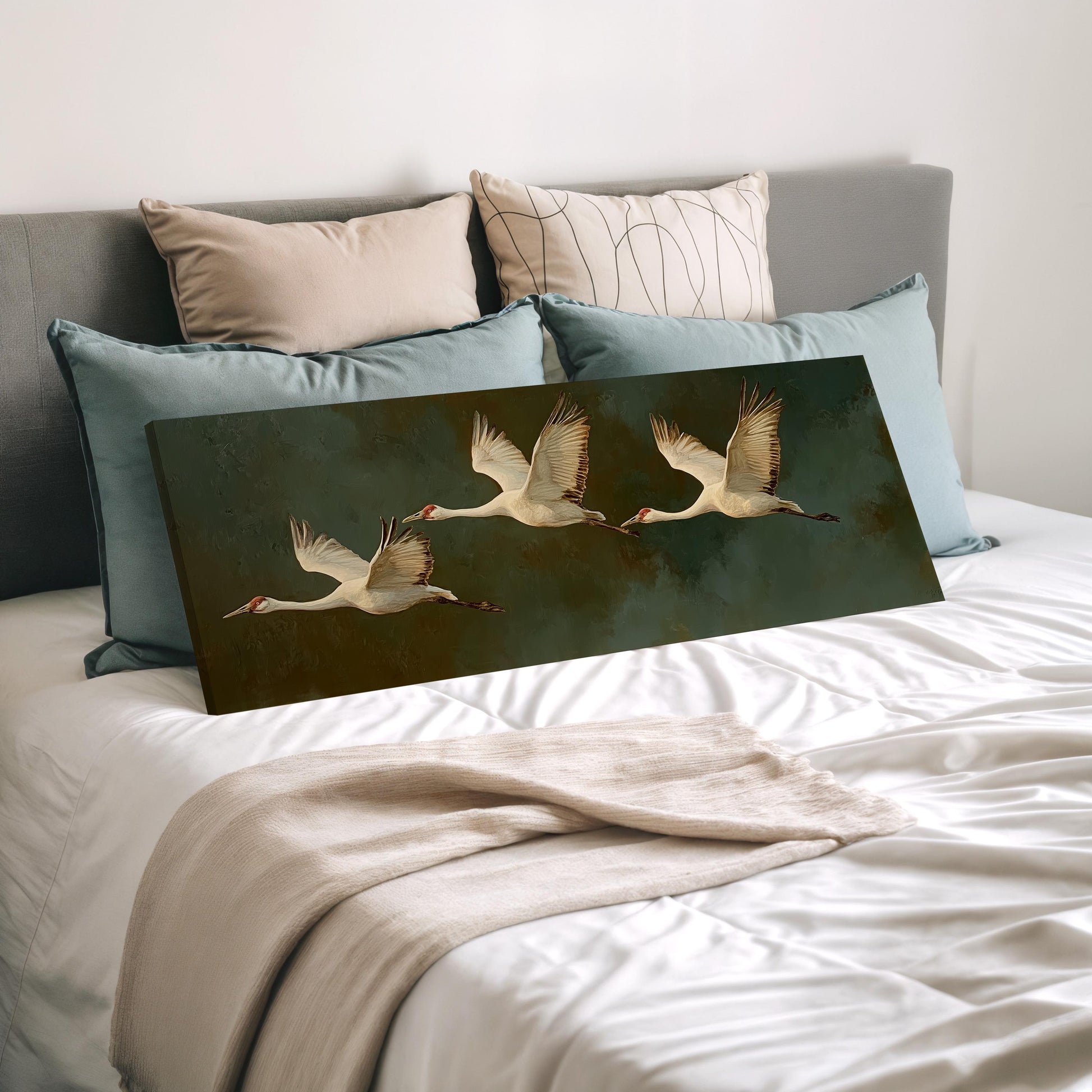 a bedroom with a bed and a painting of three swans in flight.