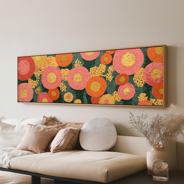 Pink circle blooms long horizontal canvas print above a sofa in a living room