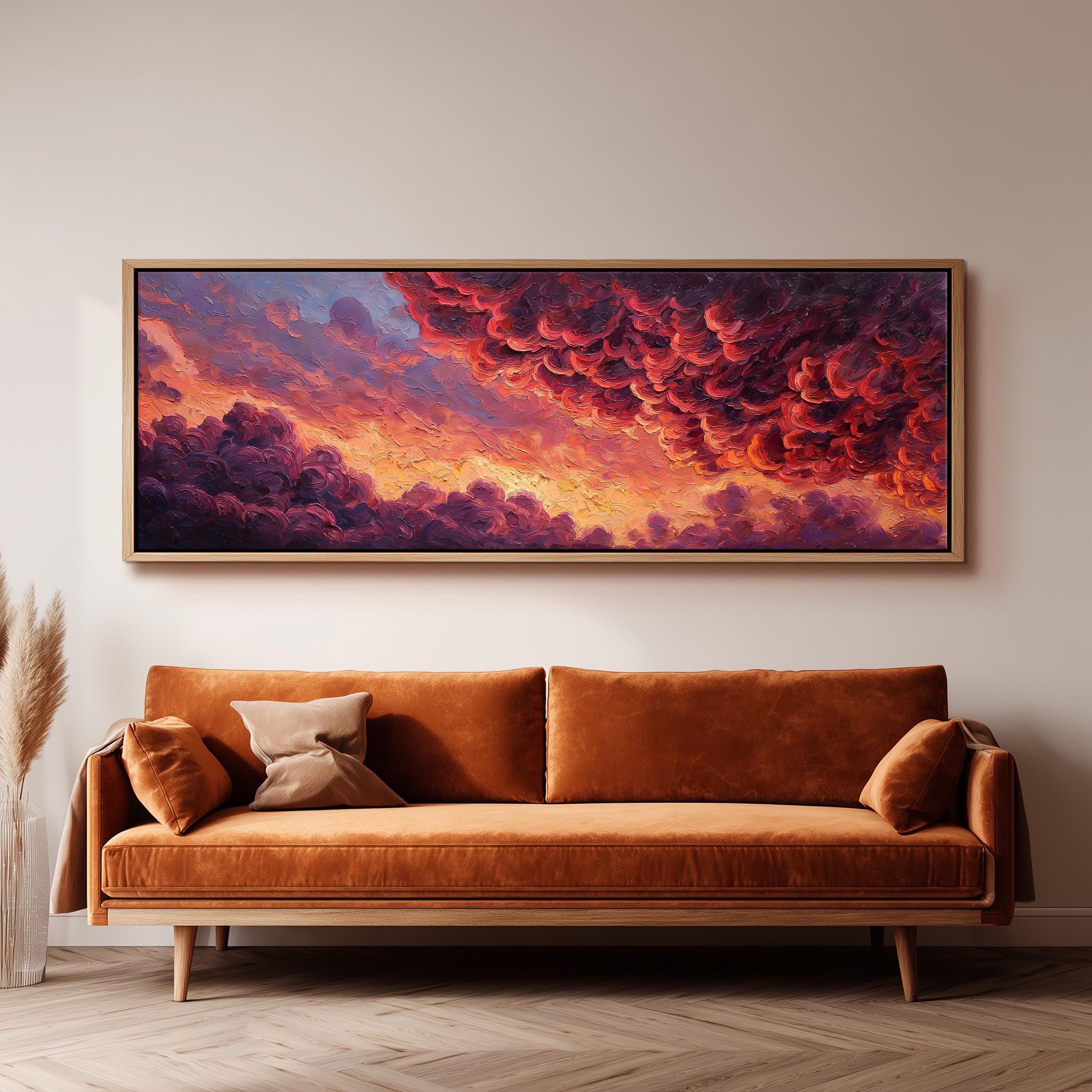 a large, framed painting of a vibrant, colorful sky with clouds hanging above a brown sofa in a living room setting.