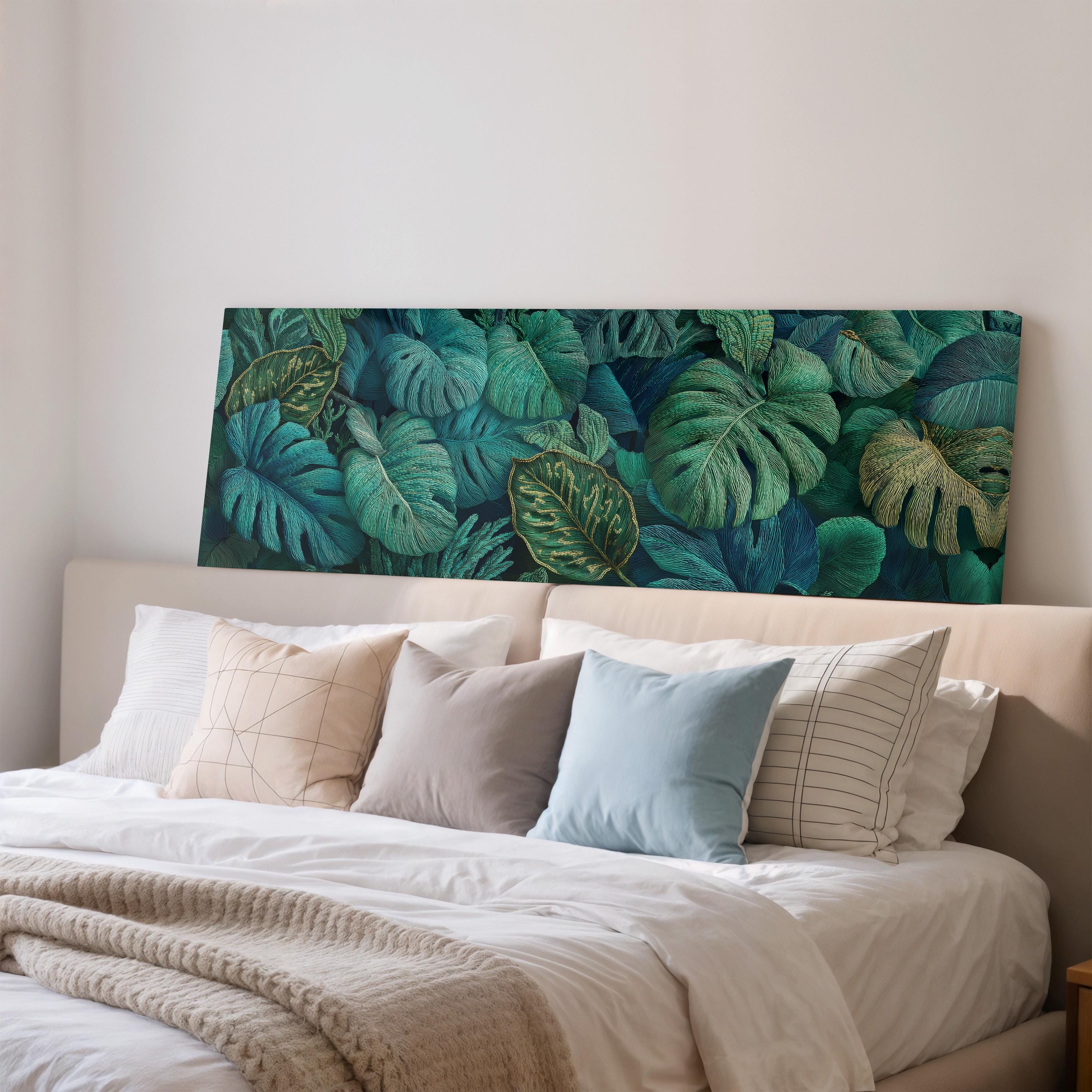 a large bed with a white headboard and a vibrant green tropical leaf pattern on the wall behind it.