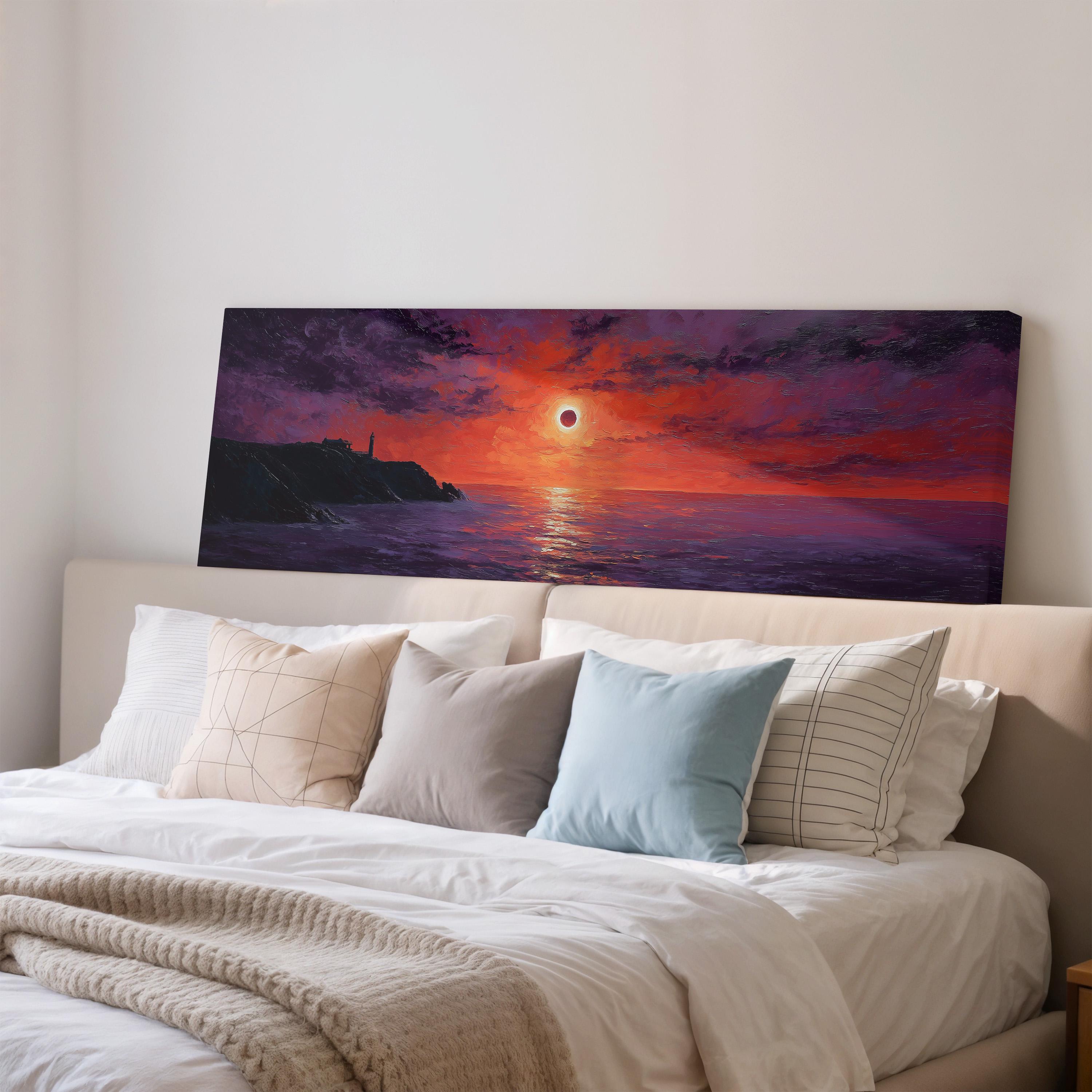 a large painting of a sunset over the ocean, hanging on a wall above a bed with white pillows and a gray blanket.