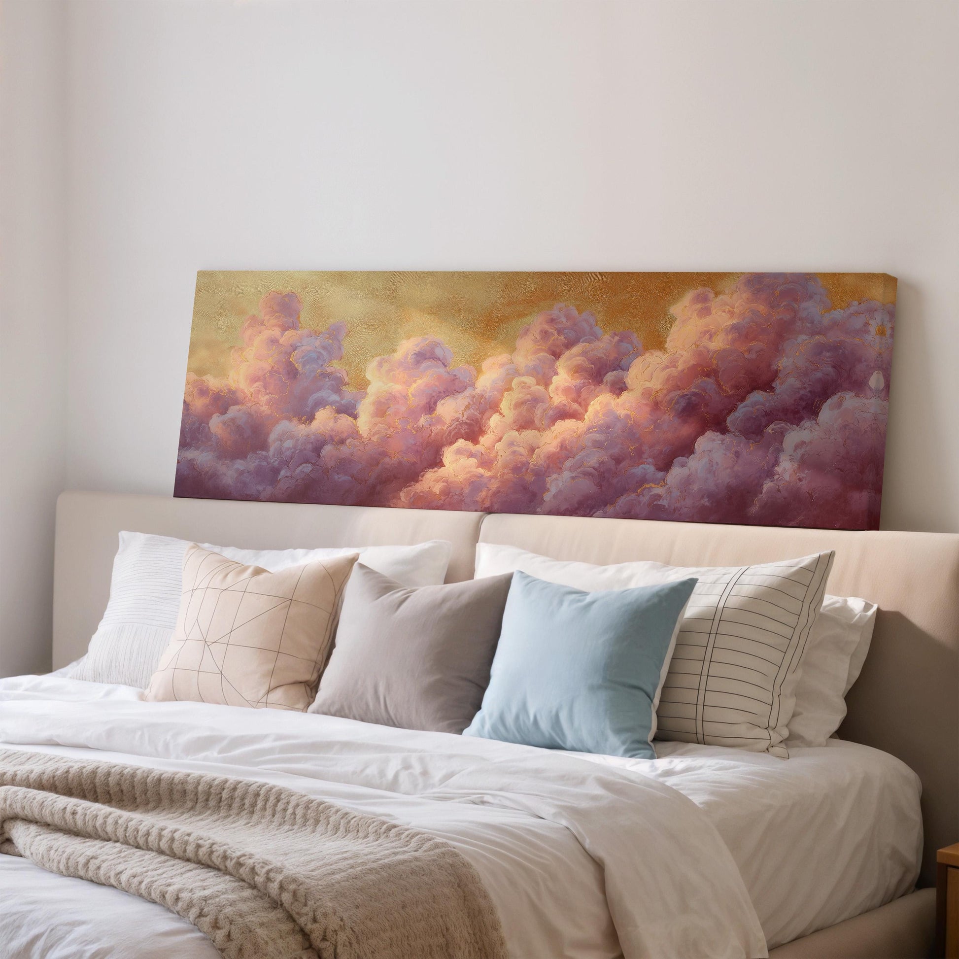 a large bed with white sheets and pillows, and a painting of clouds above it. The painting has a warm, golden hue and depicts a vibrant, colorful sky filled with fluffy, pink and purple clouds.