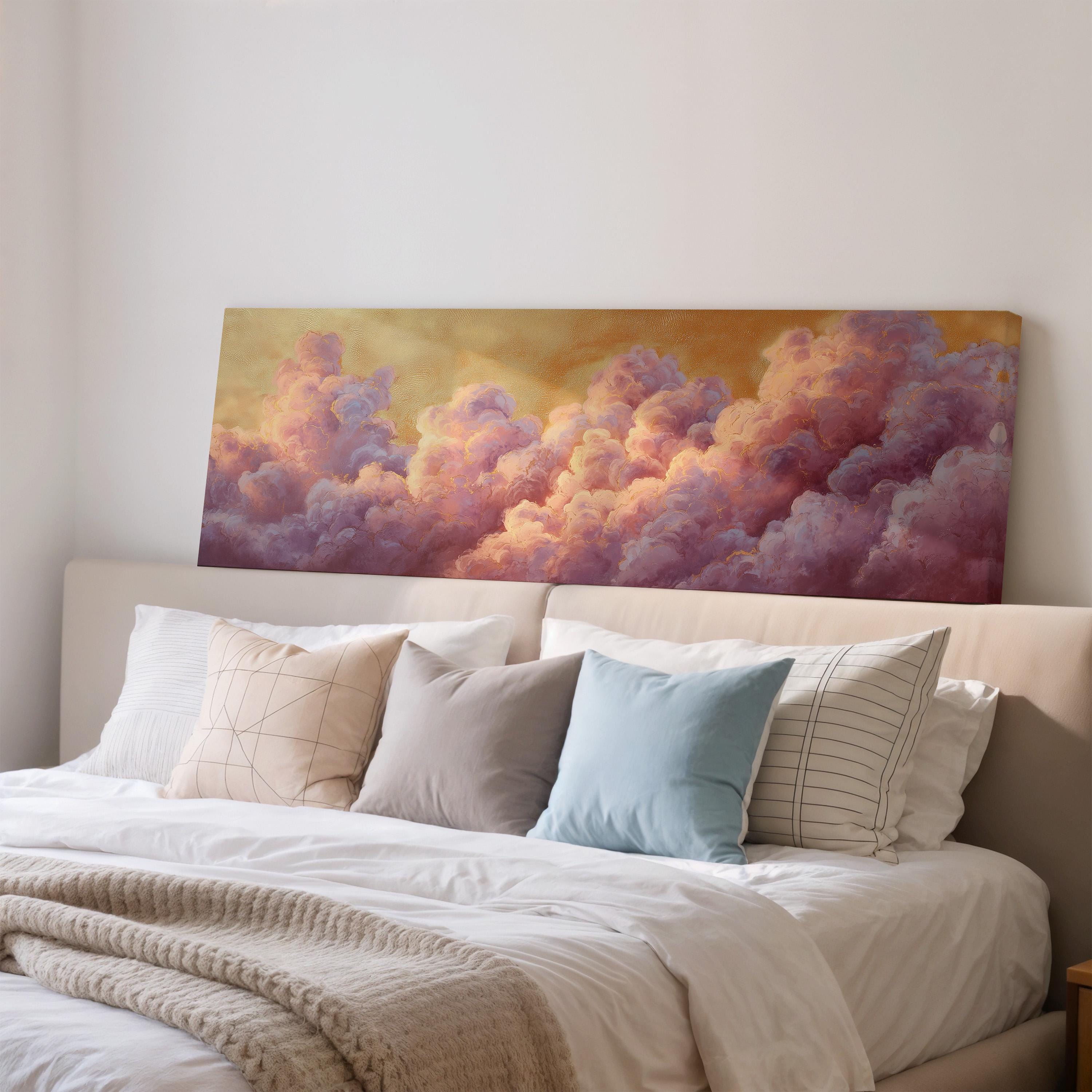 a large bed with white sheets and pillows, and a painting of clouds above it. The painting has a warm, golden hue and depicts a vibrant, colorful sky filled with fluffy, pink and purple clouds.