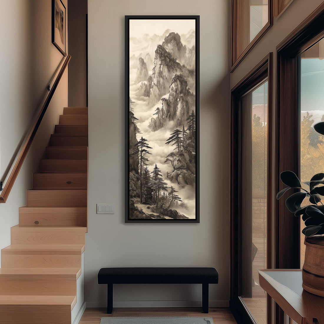 a large black and white landscape painting hanging on a wall, depicting a mountainous scene with trees and a winding path.