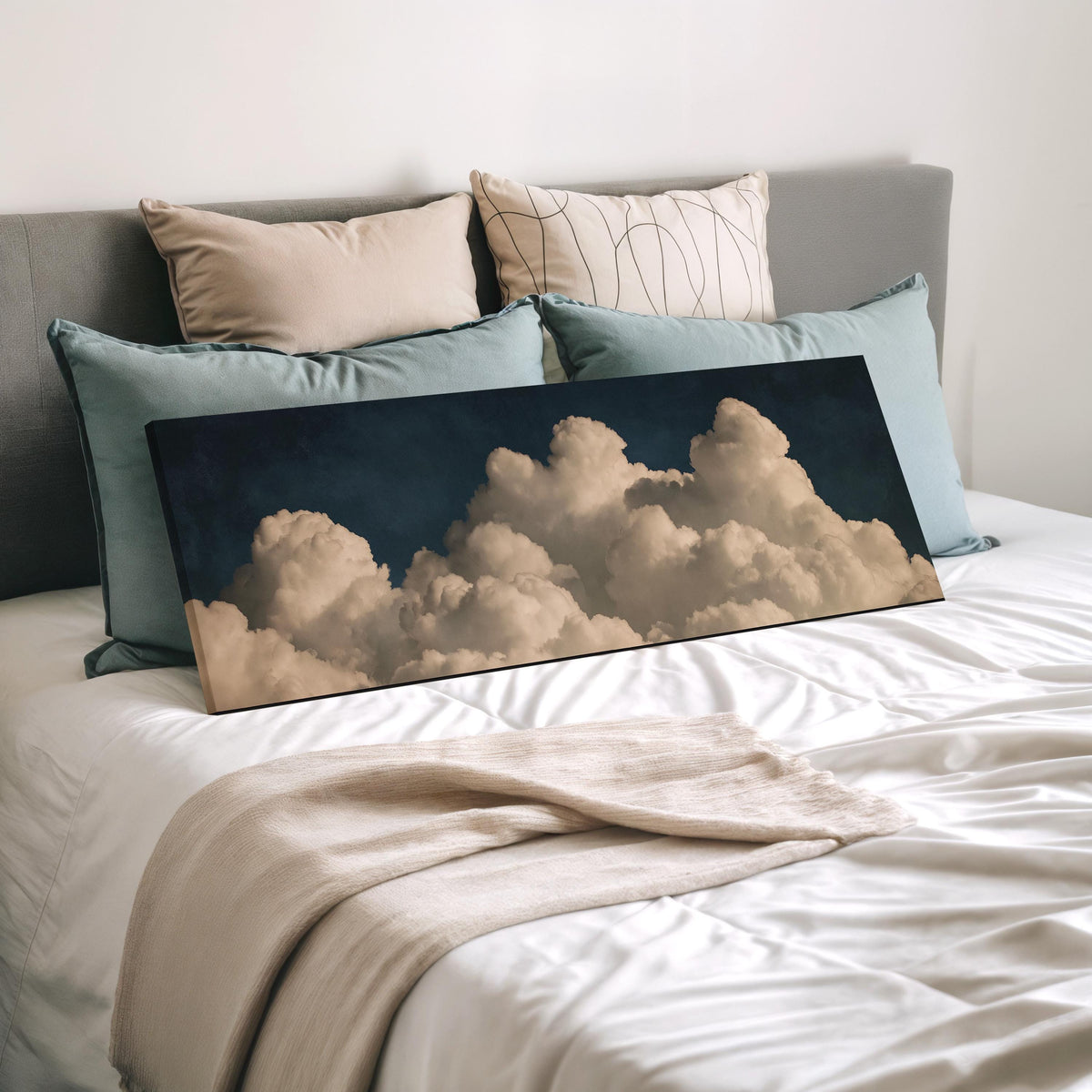 Cumulus clouds against a dark night sky wide panoramic canvas print laid on a bed to show its size