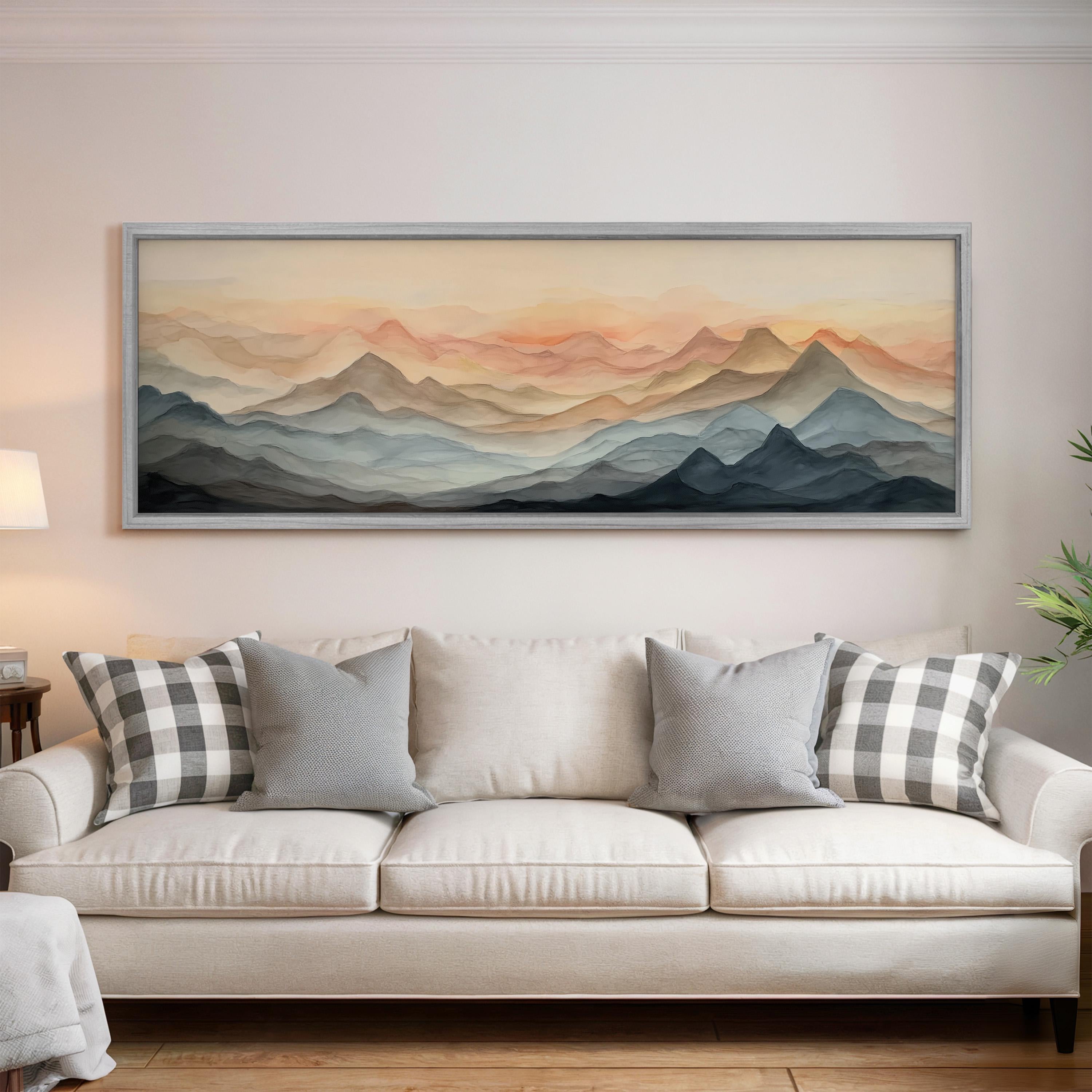 a large, framed painting of mountains hanging on a wall above a white couch with gray and white plaid throw pillows.