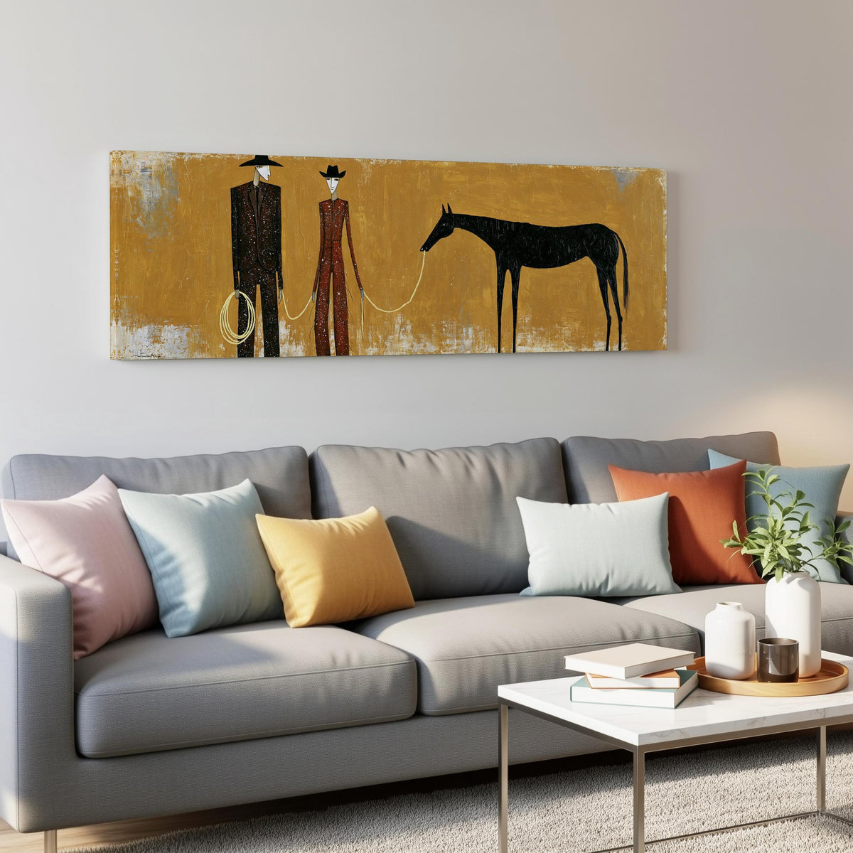 Two cowboys with a dark horse on gold panoramic canvas print above a grey sofa in a living room