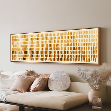 Brushmarks fading from cream to amber long horizontal canvas print above a sofa in a living room