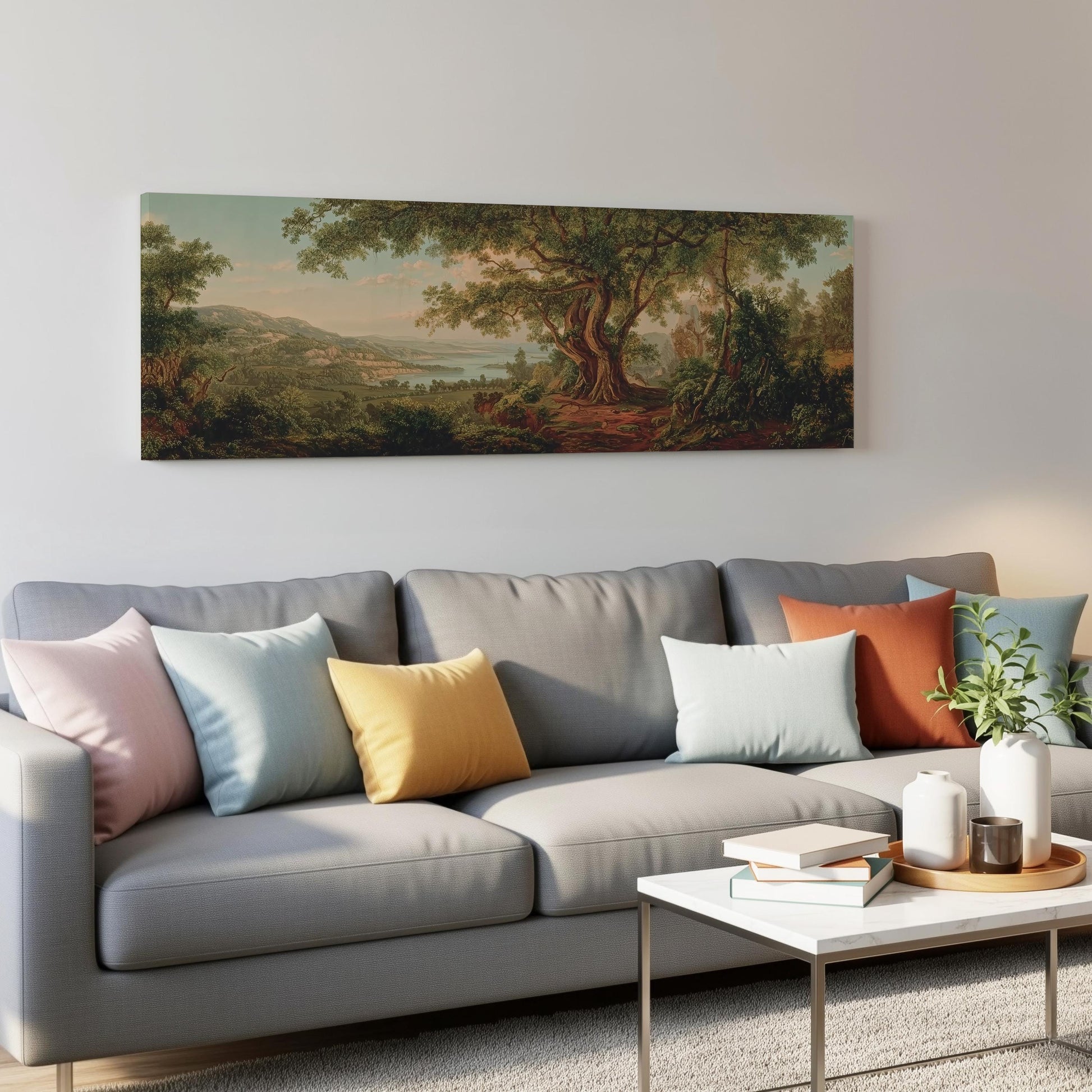 a living room with a gray sofa adorned with colorful throw pillows, a white coffee table, and a painting of a lush forest landscape hanging on the wall above the sofa.