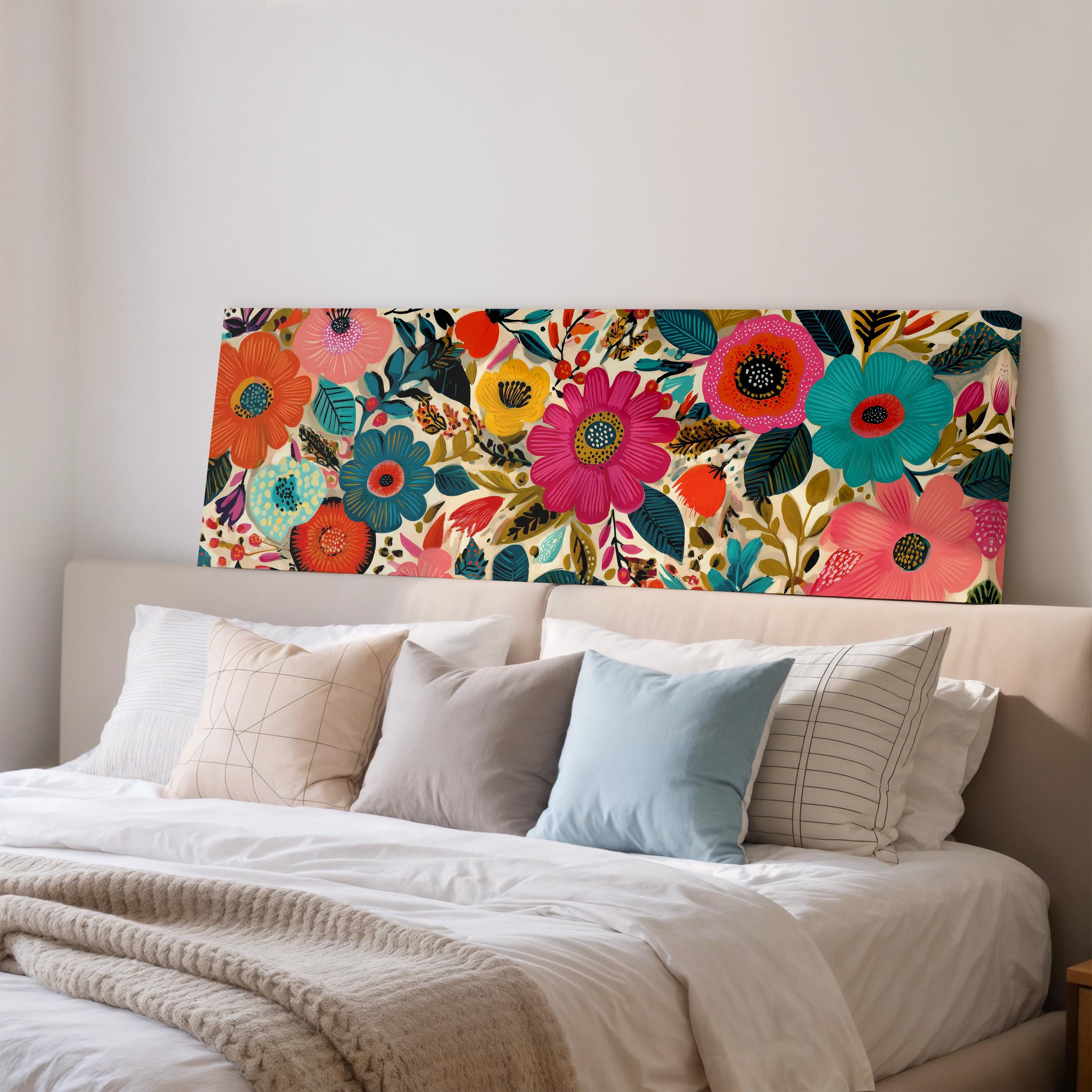a bedroom with a large floral print on the wall behind a bed, which is adorned with a variety of colorful pillows.