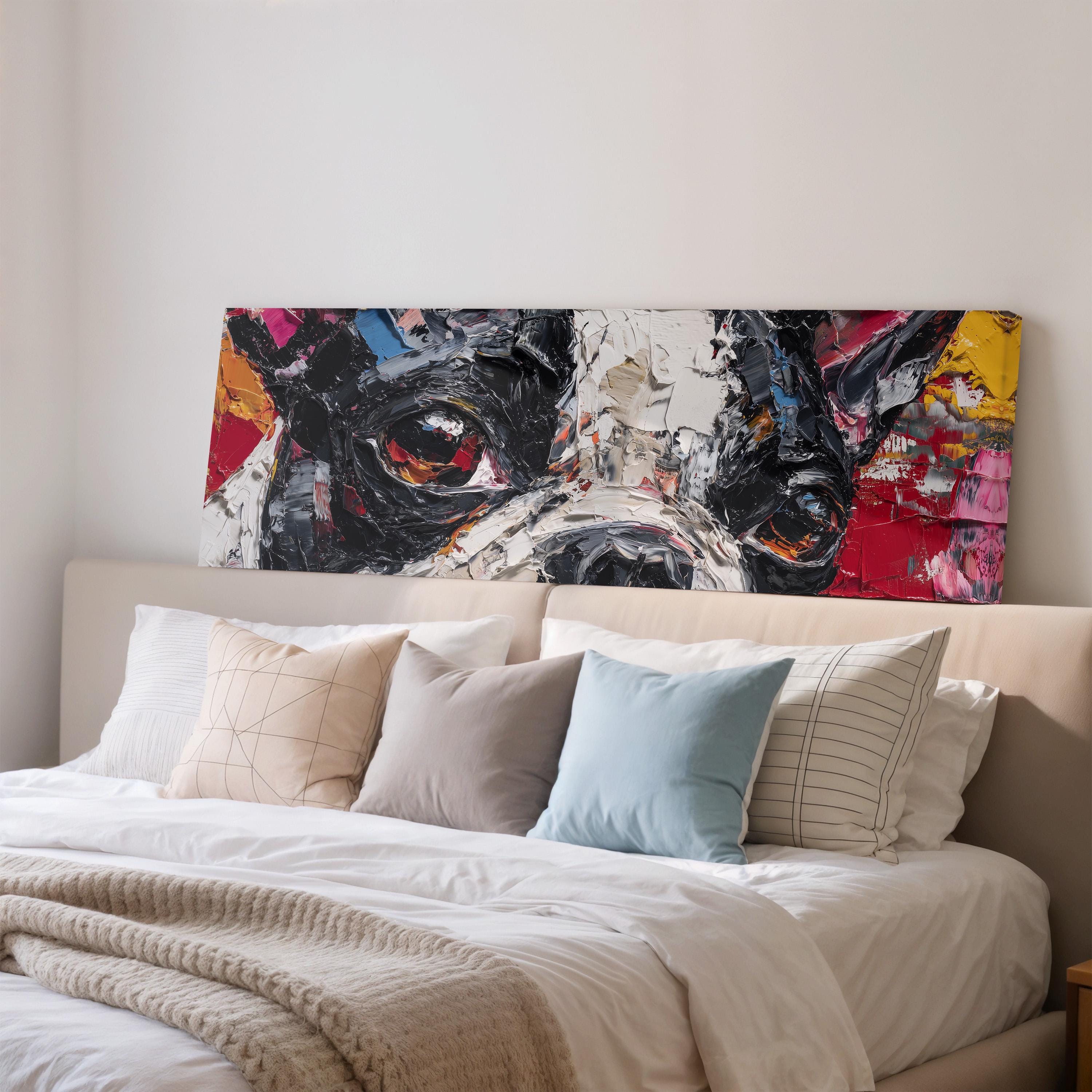 a large, colorful painting of a dog's face hanging above a bed with white sheets and pillows.