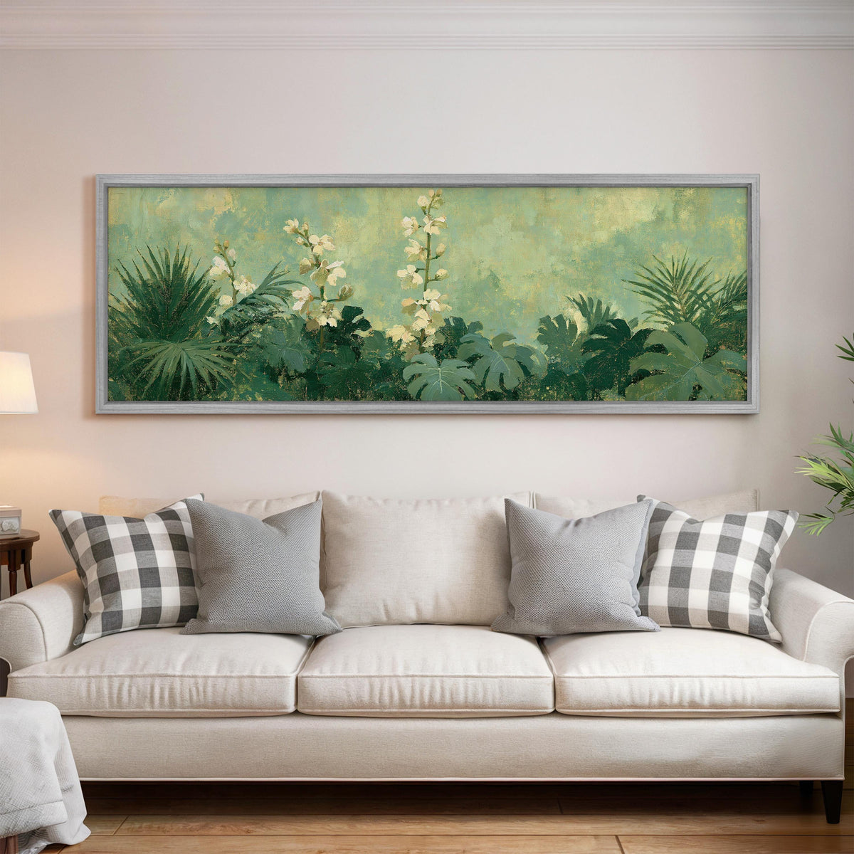 Tropical white blooms in green foliage panoramic canvas print above a white sofa in a bright living room