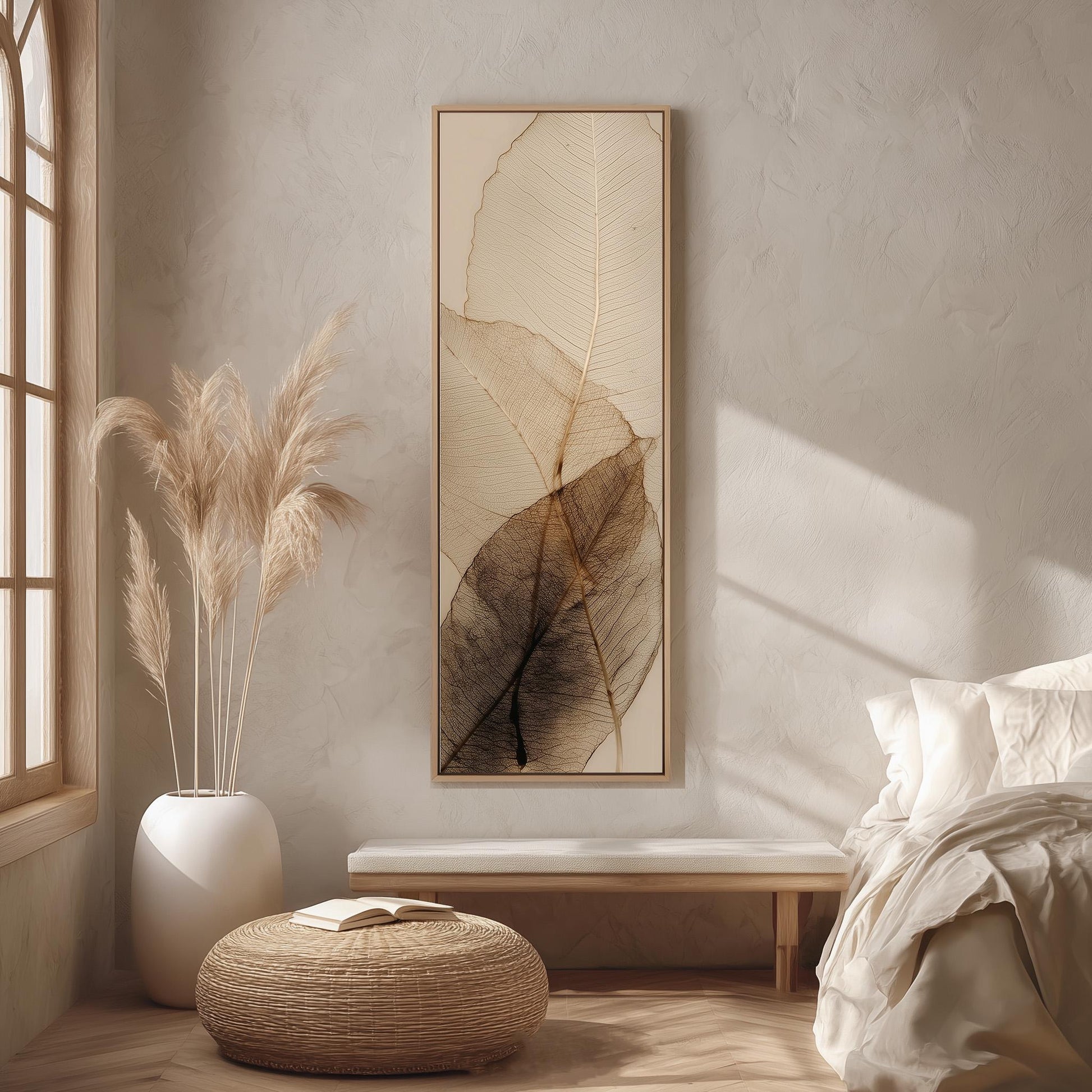 a serene and minimalist bedroom interior, featuring a large framed artwork of leafy textures on the wall, a white bed with a white pillow, a white ottoman, and a potted plant with long, feathery leaves.
