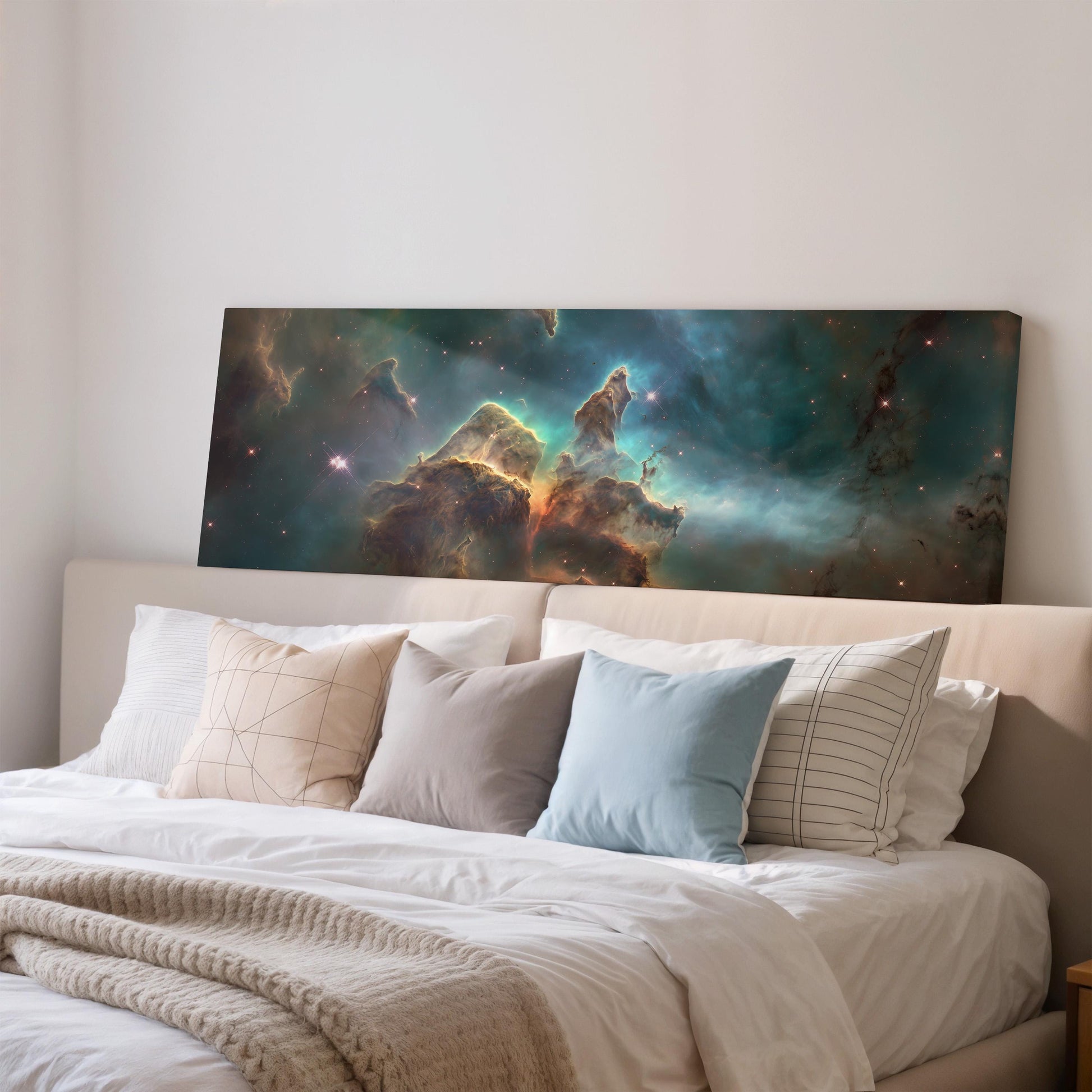 a large, colorful painting of a nebula hanging on a wall above a bed with white bedding and pillows.